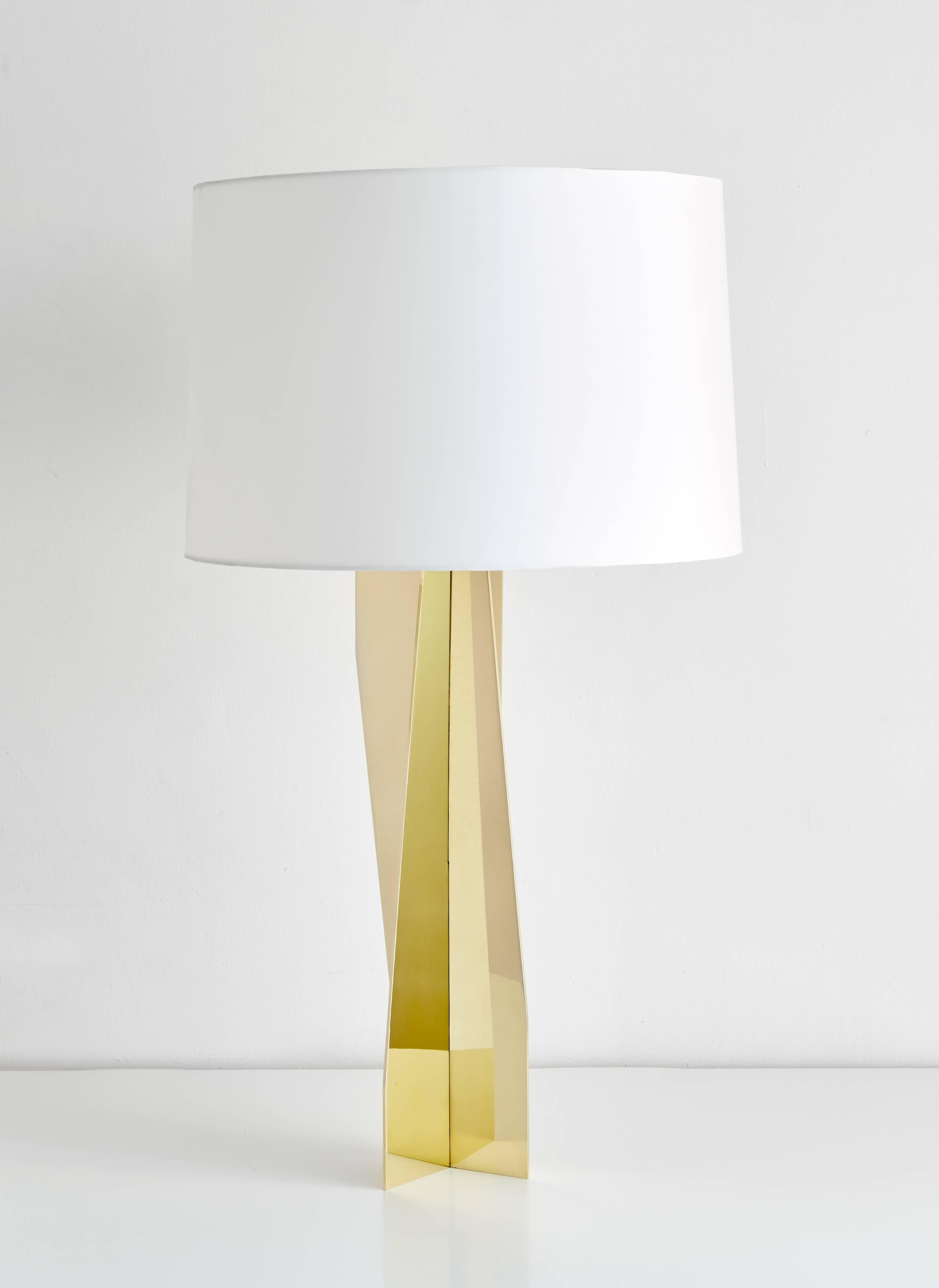 Geometric, reflective, strikingly modern, this made to order brass lamp can be customized in any size finish or material. Shown here in mirror polished finish with a white silk shade.
