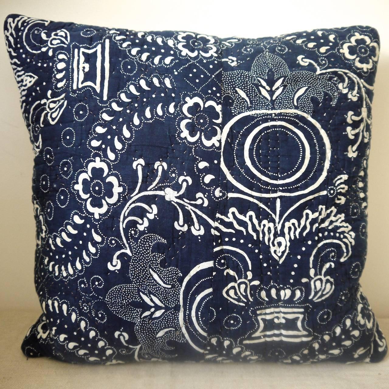French dated 1800 indigo resist block printed cotton cushion. A striking design of pomegranite and floral motifs. Simply quilted and printed on a soft cotton and backed in a dyed 19th century French linen. There is a seam about halfway across with