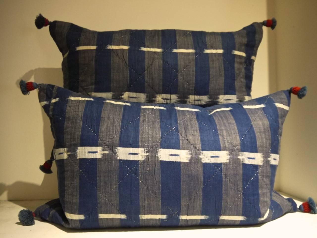 19th century French flame / ikat cotton cushions in a strong shade of inky indigo. Simply quilted in a hexagonal pattern. With a wool 19th century tassel in each corner and backed in a dyed 19th century linen and slip stitched closed with a duck