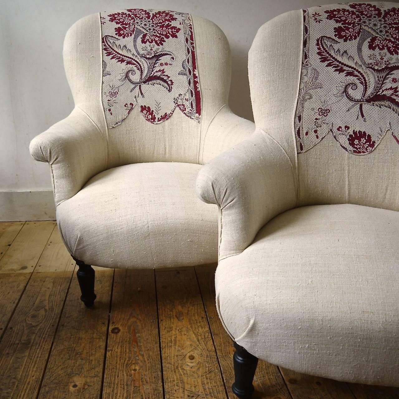 Pair of French 19th century armchairs newly upholstered in a 19th century French pale honey colored heavy linen with an 18th century French printed detail inserted on the backs. This circa 1780s block printed design has a pretty scalloped edge with