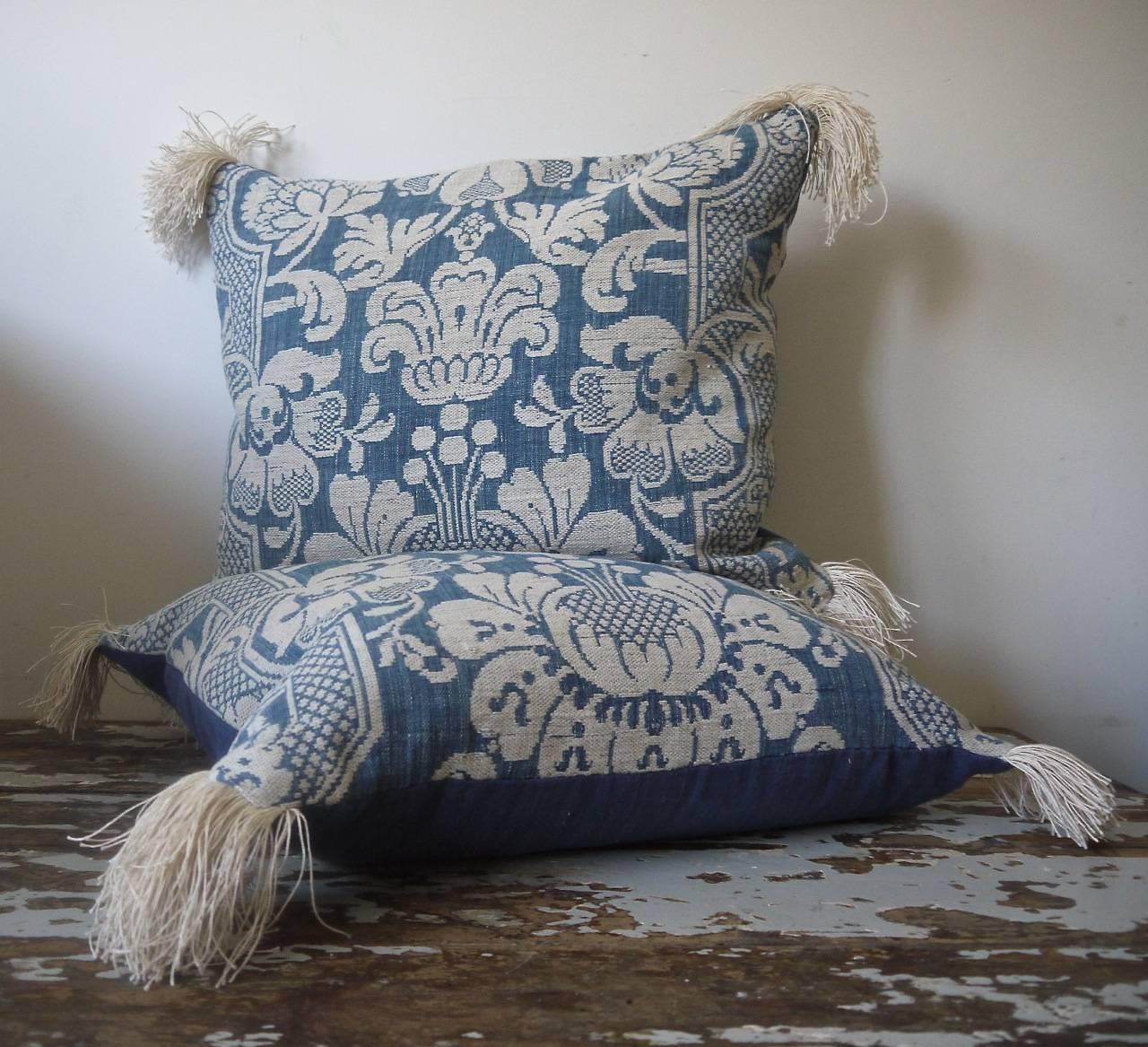 French, circa 1760s woven blue and white linen and cotton cushions. Wonderful texture and contrast of weaves and yarns. Antique French linen fringing at the corners and backed in a dyed 19th century, French linen. Slipstitched closed with a duck