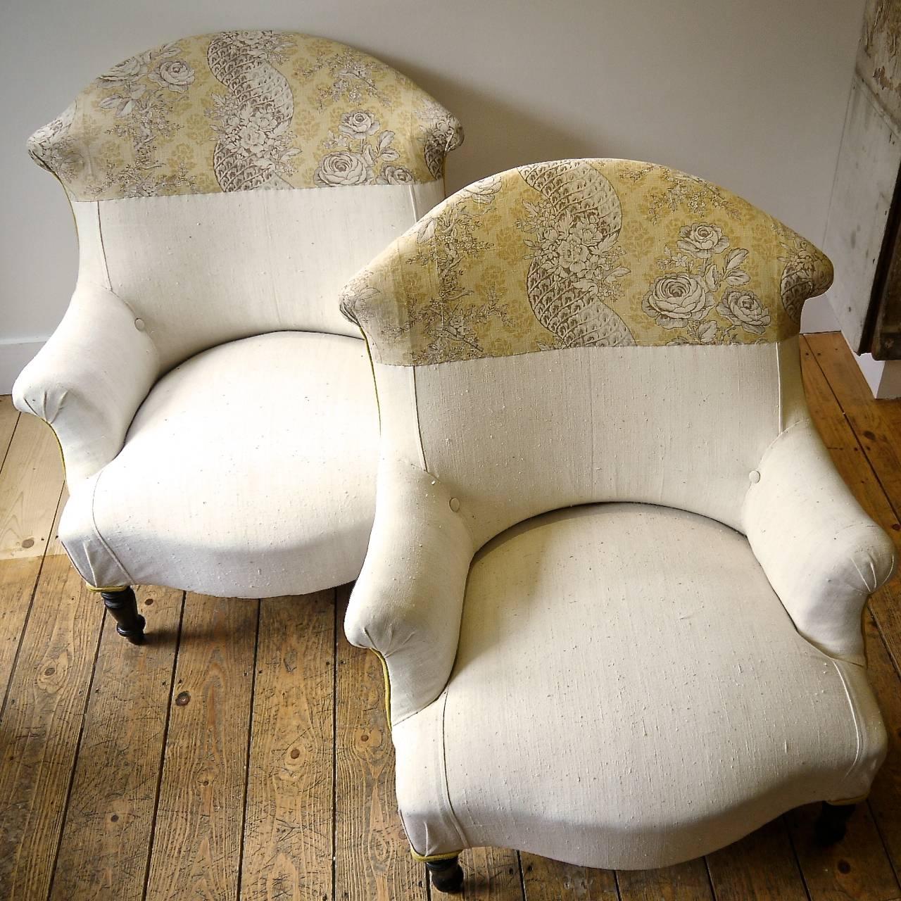 Pair of French Napoleon III armchairs stylishly covered in a 19th century French plain linen with the backs in a printed linen of roses and twisting columns of flowers .Contrasting piping of hand dyed saffron yellow linen.