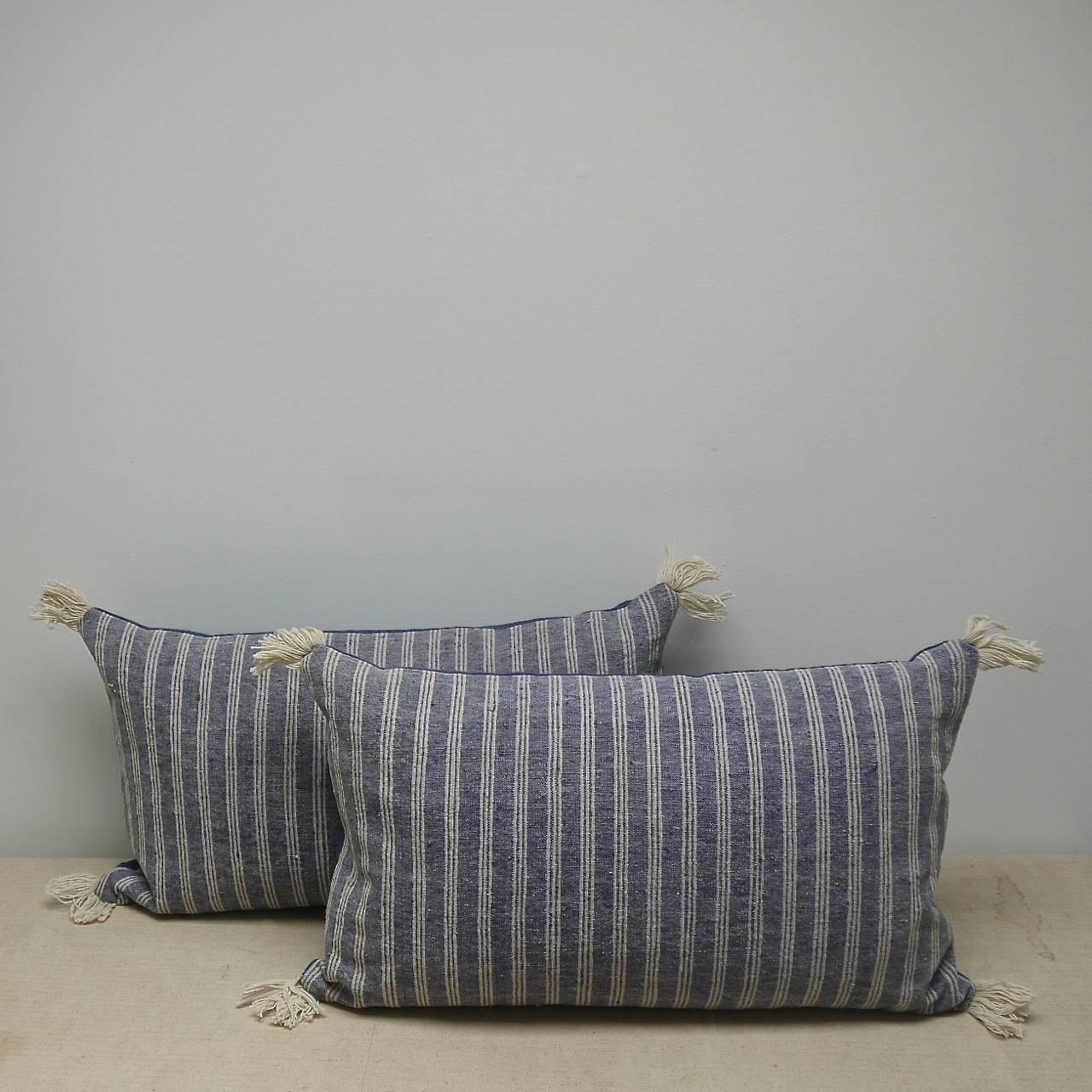 French 19th century cotton and wool striped cushions with antique wool fringing on each corner. The soft indigo stripe alternates with one of a very pale greenish hue.
Backed with a dyed 19th century French linen and slip-stitched closed.