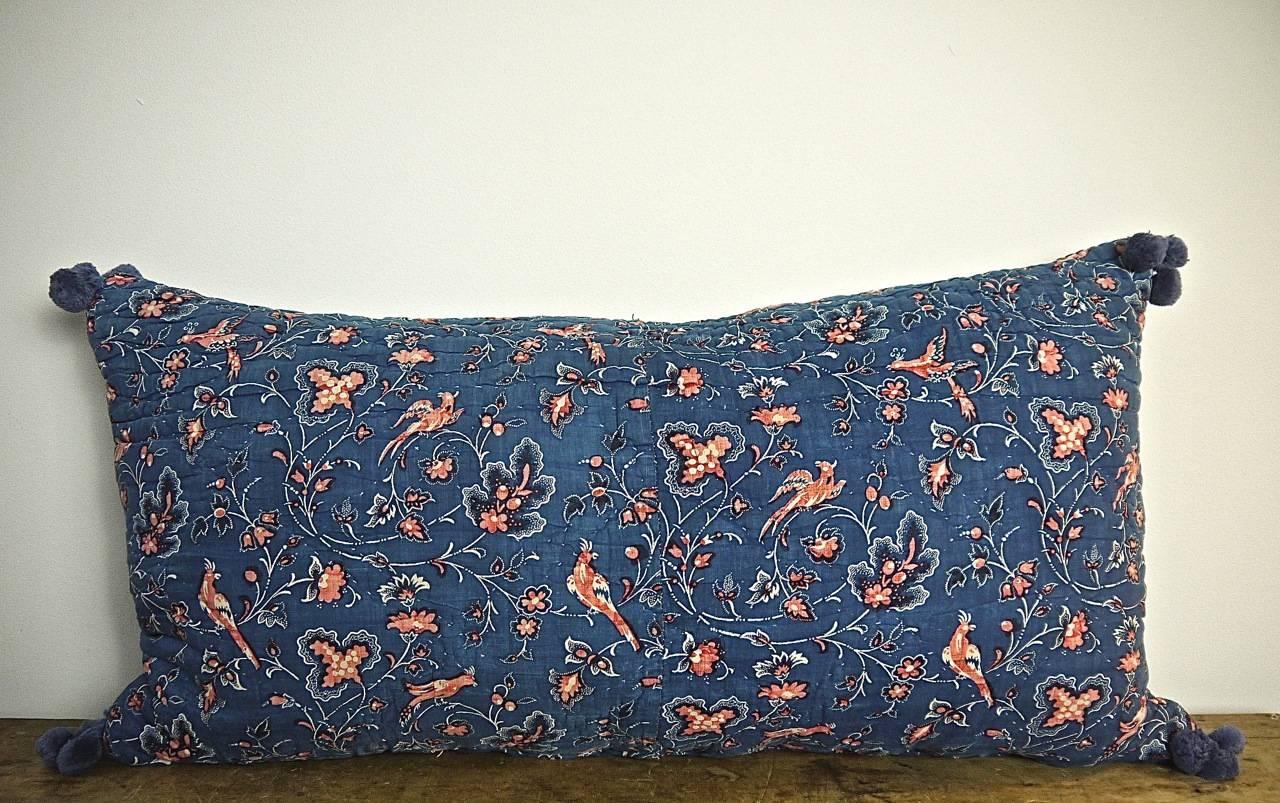French early 19th century cushion block-printed indigo resist and pretty faded red birds and flowers on a soft quilted cotton.With vintage French cotton bobbles on each corner.Backed in a natural indigo hand dyed 19th century French linen and