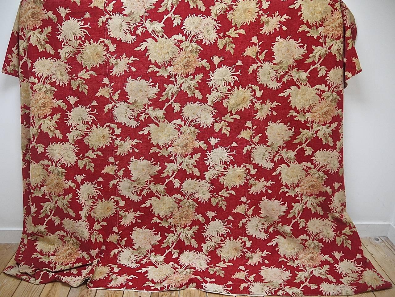 A late 19th century French very striking design of softly faded pale beige, pale pinks large-scale chrysanthemums on a turkey red ground of medium weight cotton. Made up of three beautifully joined widths and backed in a plain cotton with a charming