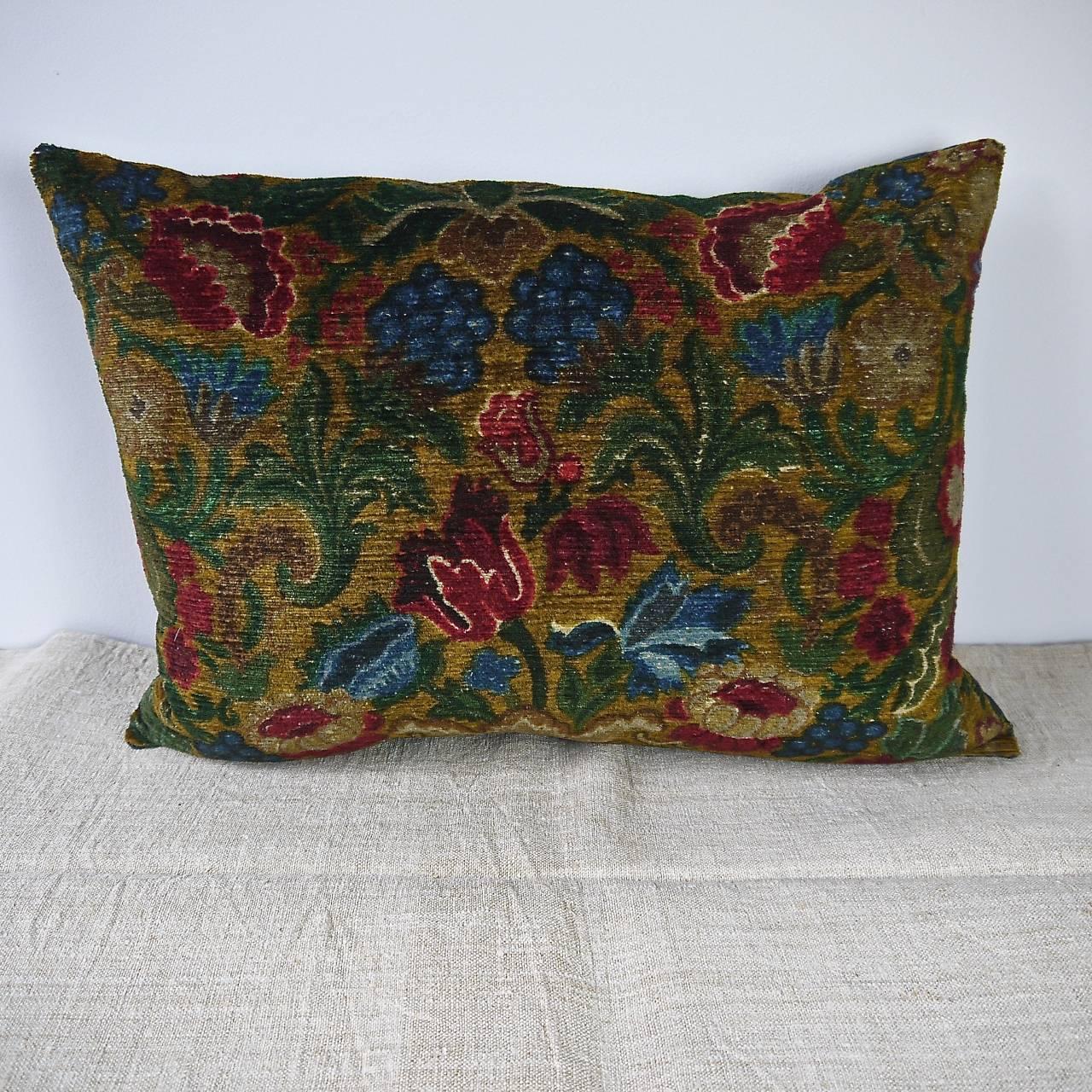 Gorgeous French, circa 1950s cotton velvet cushion printed with richly colored flowers and leaves. Backed in a hand dyed natural indigo French 19th century linen. Slipstitched closed with a duck feather cushion pad.