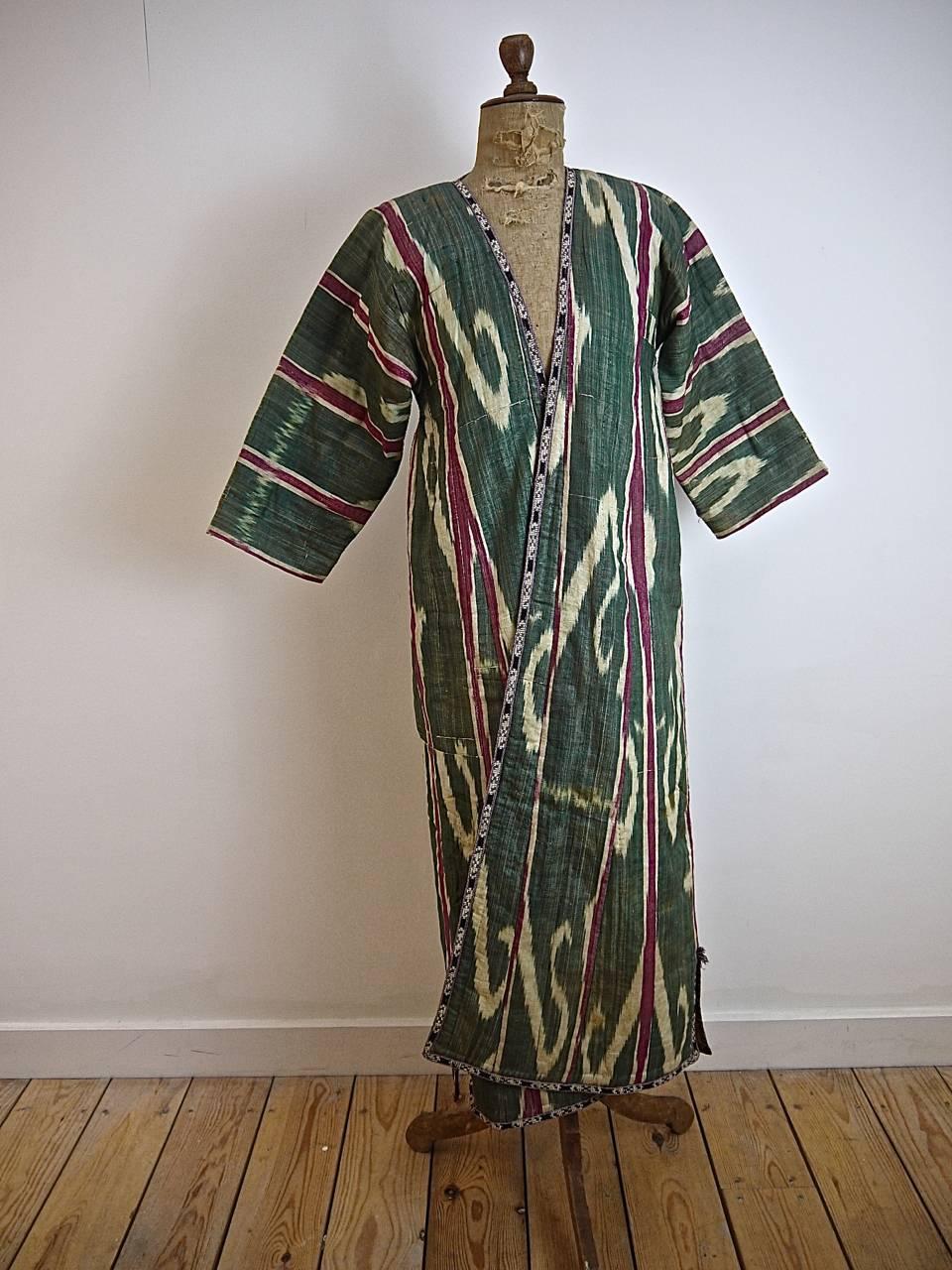 Late 19th or early 20th century silk chapan or robe from Uzbekistan with a red cotton floral print Russian lining. Lightly quilted with a wool padding.
Neck to hem 126cm
Across the chest 50 cm wide.