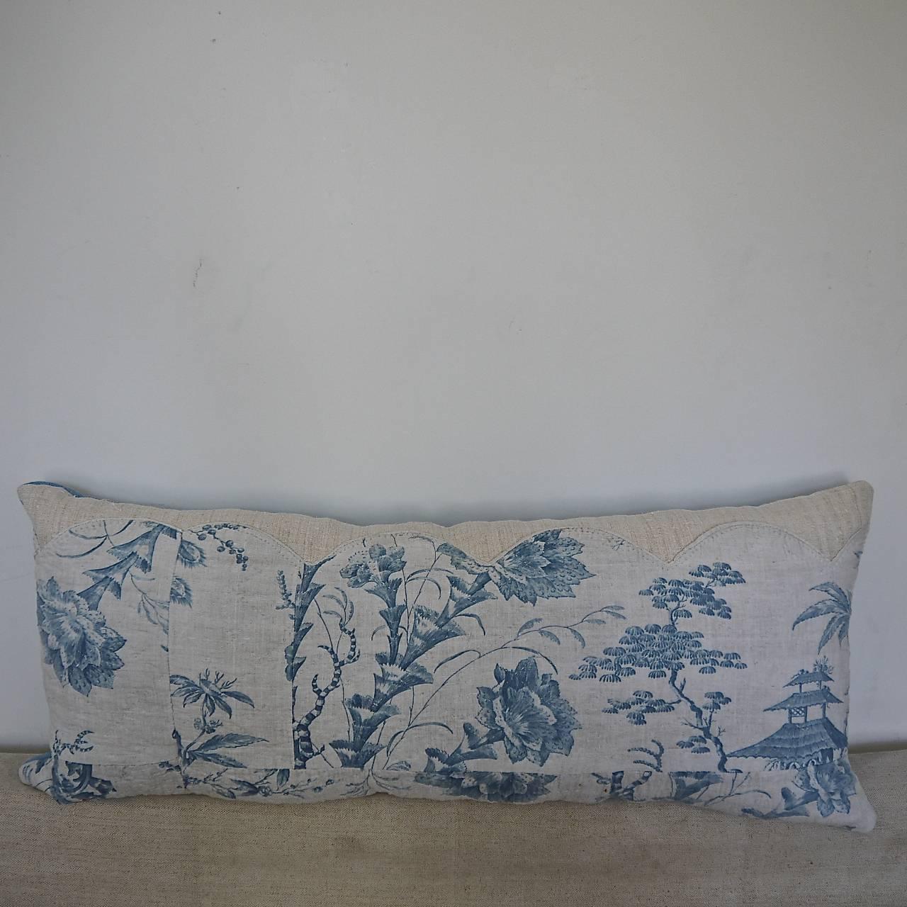  18th century French blue Chinoiserie cotton cushion made from a pelmet with its original patched pieces of large-scale flowers and a glimpse of a pagodas.It retains its original scalloped edge which has been stitched onto a 19th century French