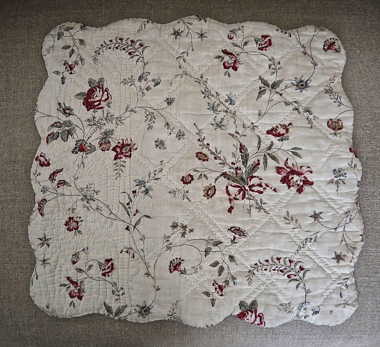 Very pretty 18th century French blockprinted and scalloped edged quilted cotton square. One side a bunches of bowed flowers with scattered roses and trailing branches. This side is in a fair condition with some faded stains and a fair amount of