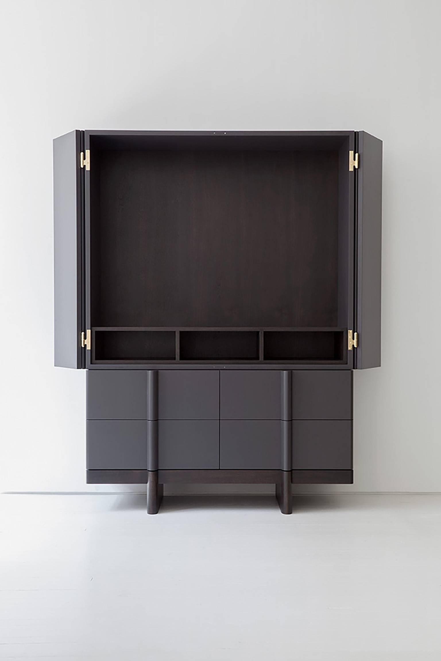 The Crain Cabinet is handcrafted in our Brooklyn studio. It is constructed of lacquered wood with a walnut interior and base and polished brass hardware. 