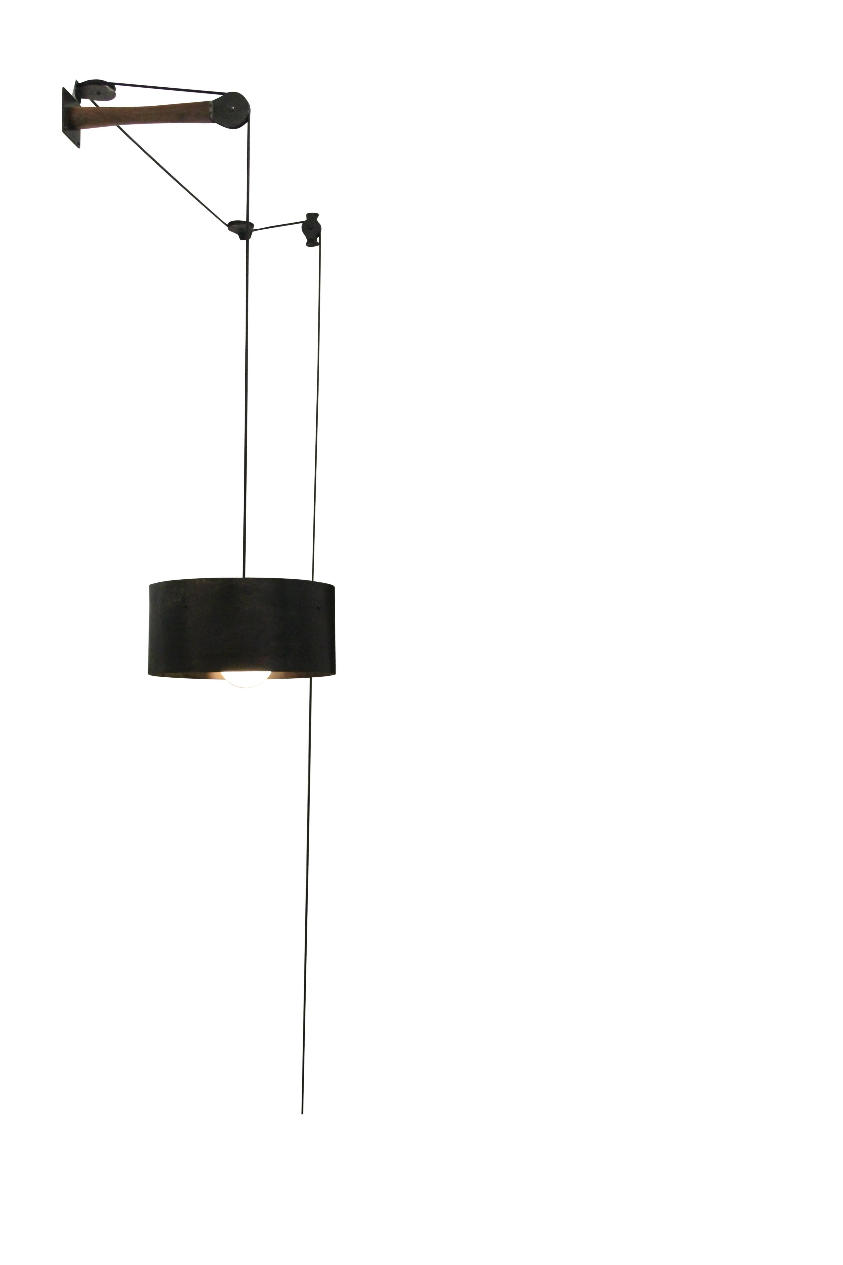 The pulley light is a truly dynamic piece. The light is easily raised and lowered utilizing pulleys, whose unique arrangement allows for true customization for each space. The shade is made from hand-bent cold-rolled steel which Stefan Rurak