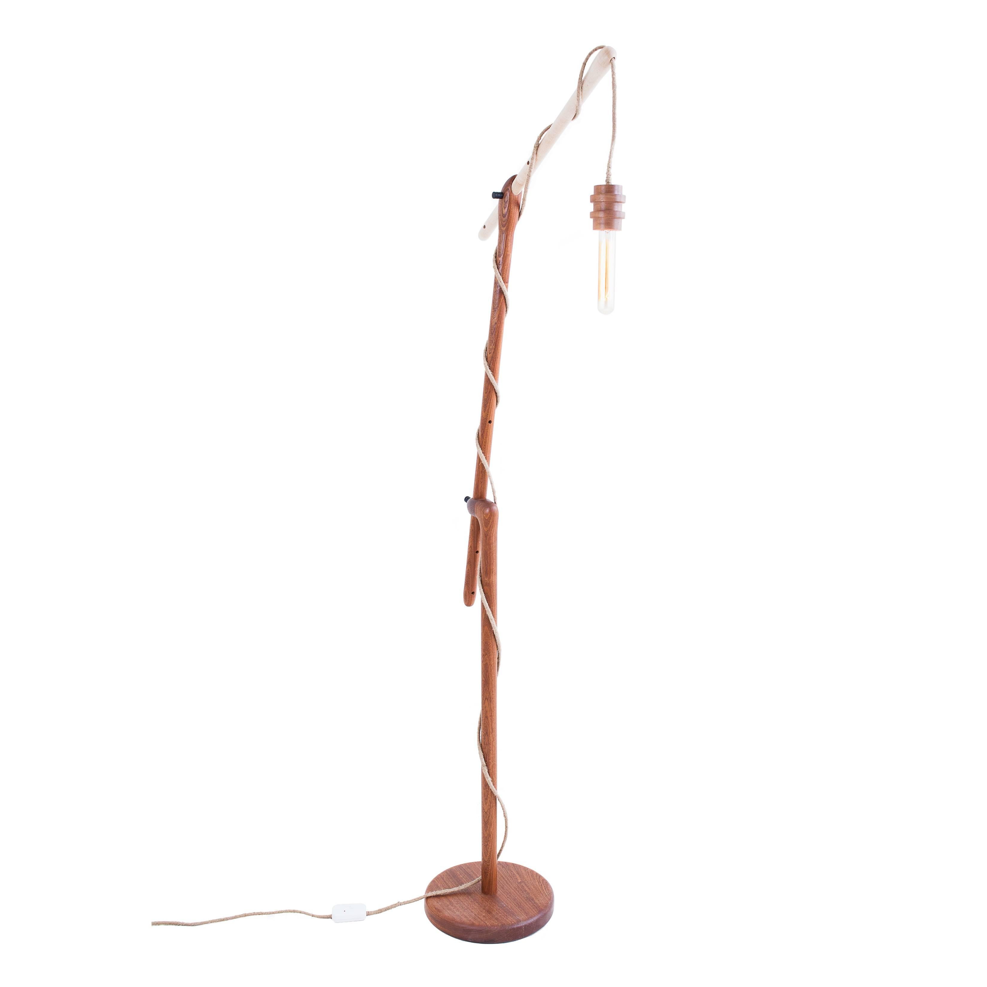 The reading light is an adjustable floor lamp with an all wood system. All elements are hand-turned solid wood. Gabon ebony pins allow the reader to adjust the sapele and maple arms to the desired angle and height. The solid hanging pendant light