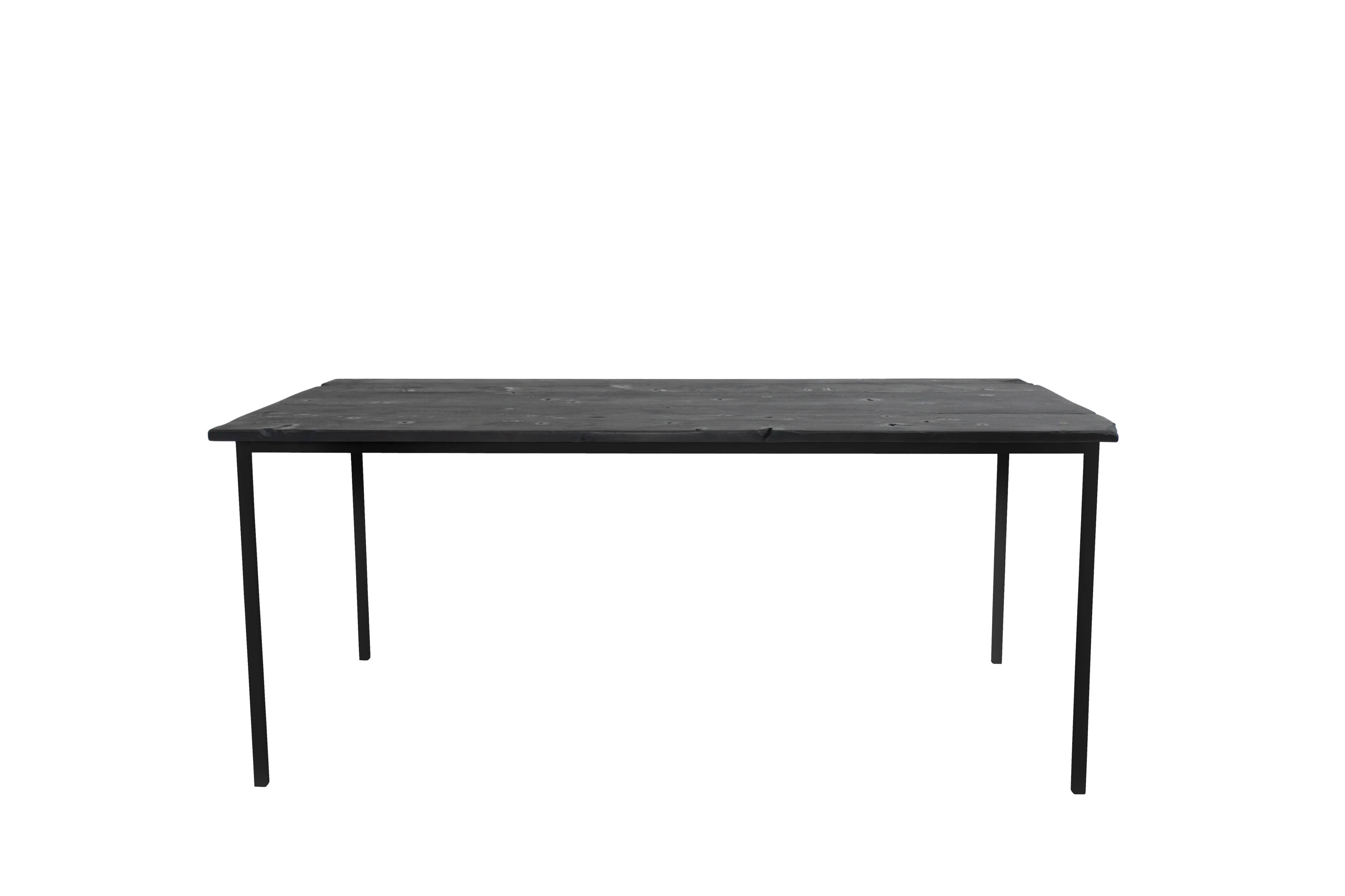 "Hephaestus' Charred Table" is a simple, elegant and modern dining that features a top made from historic decommissioned NYC water tower wood which has been torched and sealed with oil to attain its rich dark texture. The base is welded