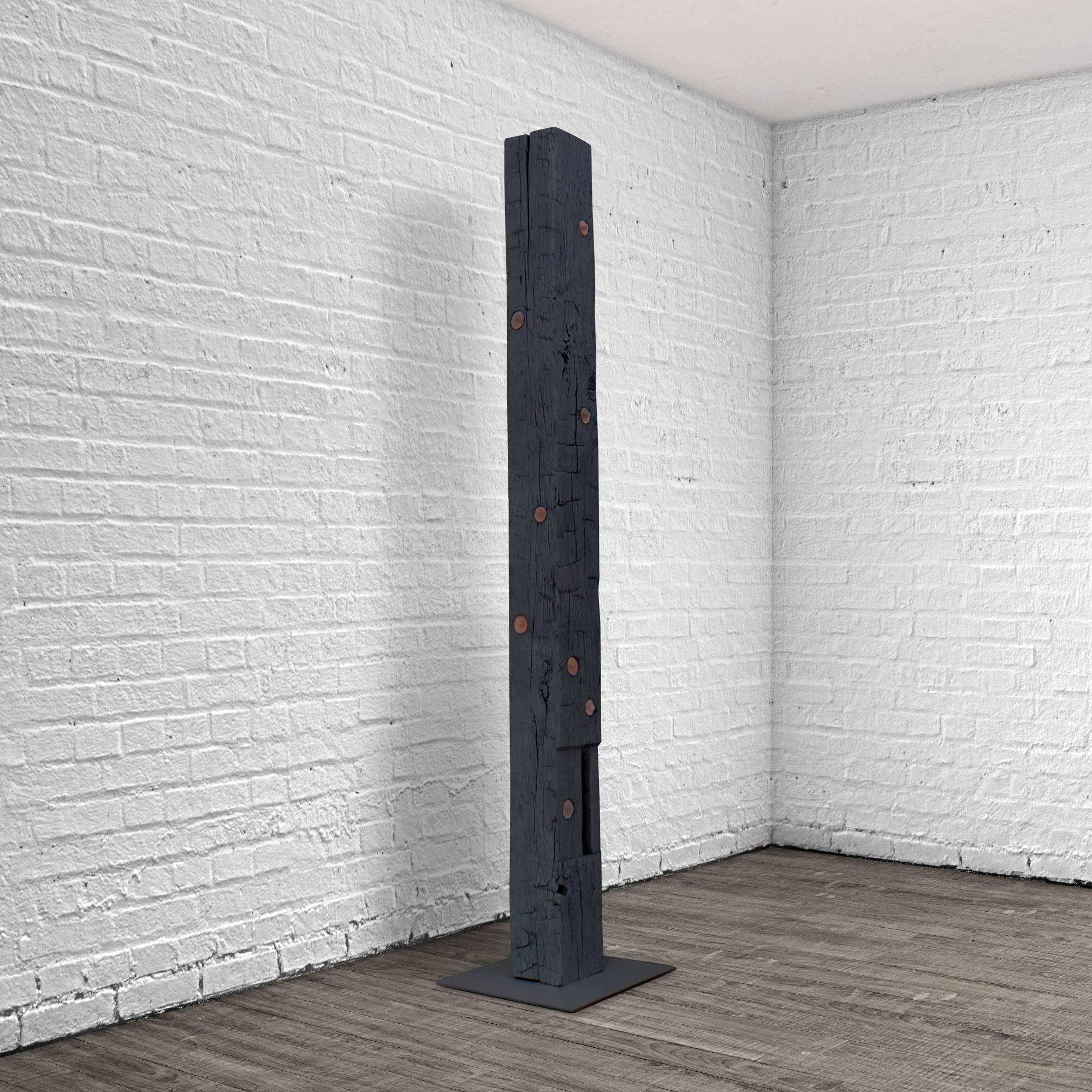 The TOTEM is an upright sculpture with storage. This structural Oak beam dating from the 1860s was salvaged from a historic Bed-Sty brownstone and features hand-hewn adze marks and hand-cut mortises. The TOTEM has 13 circular drawers that were