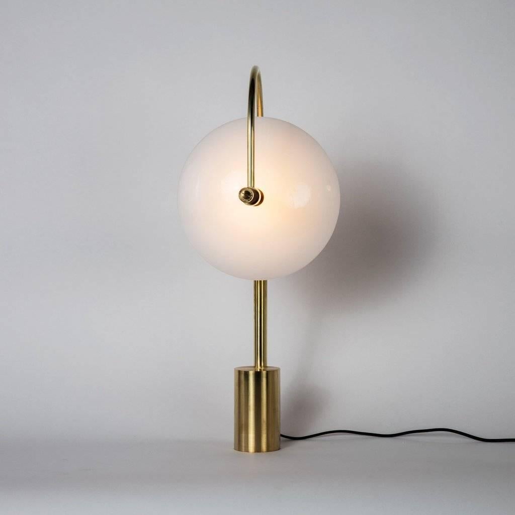 The Aperture series was created to provide a beautiful quality of light by combining bounce and ambient glow. The light source is held in a hand-spun perforated brass dome on one side, while a hand-bent tube arcs around the other; Diffusing and