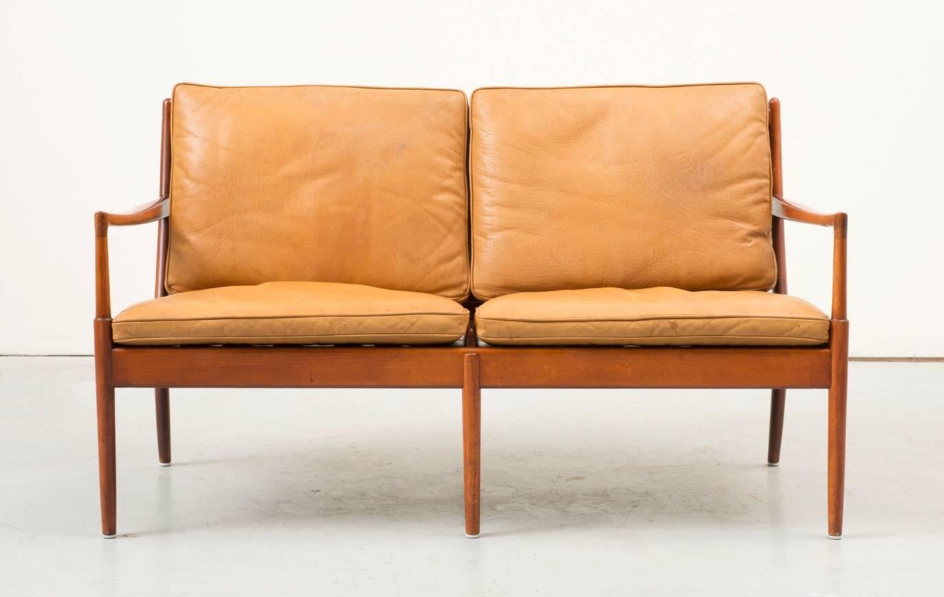 Beautiful example of this rare settee in beech and gorgeous carmel leather. Excellent vintage condition with minimal signs of use and wonderful patina.
       