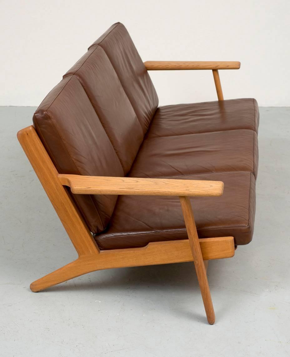 Hans Wegner GE290 paddle arm sofa in oak and soft brown leather, GETAMA, 1950s.