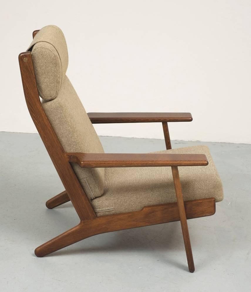 High back lounge chair GE290 designed in 1955 by Hans Wegner for GETAMA. In dark varnished solid oak with beige wool upholstery.