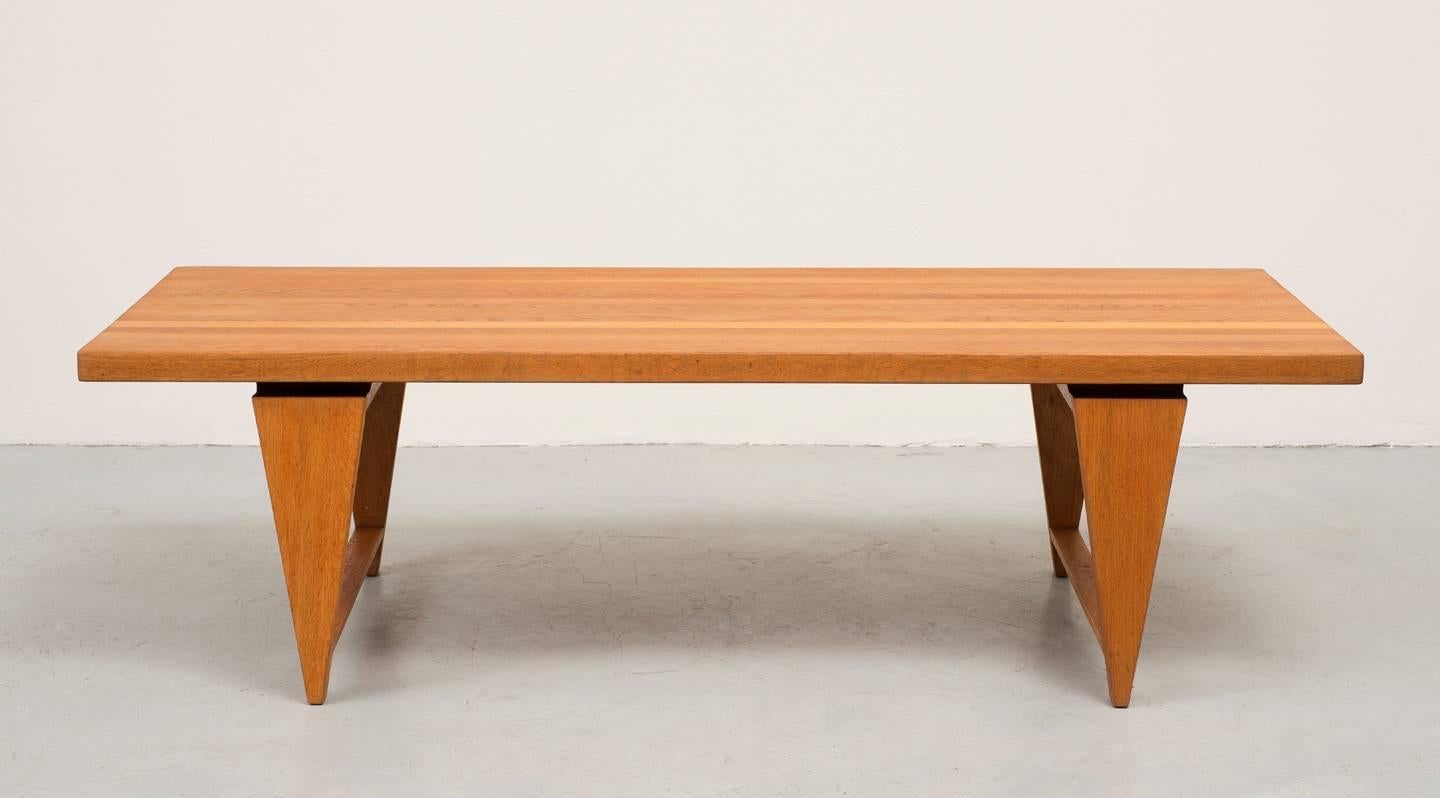 A coffee table by Illum Wikkelsø with distinctive triangular legs and floating top. In solid golden oak, this table has a strong, graceful presence, circa 1960s.