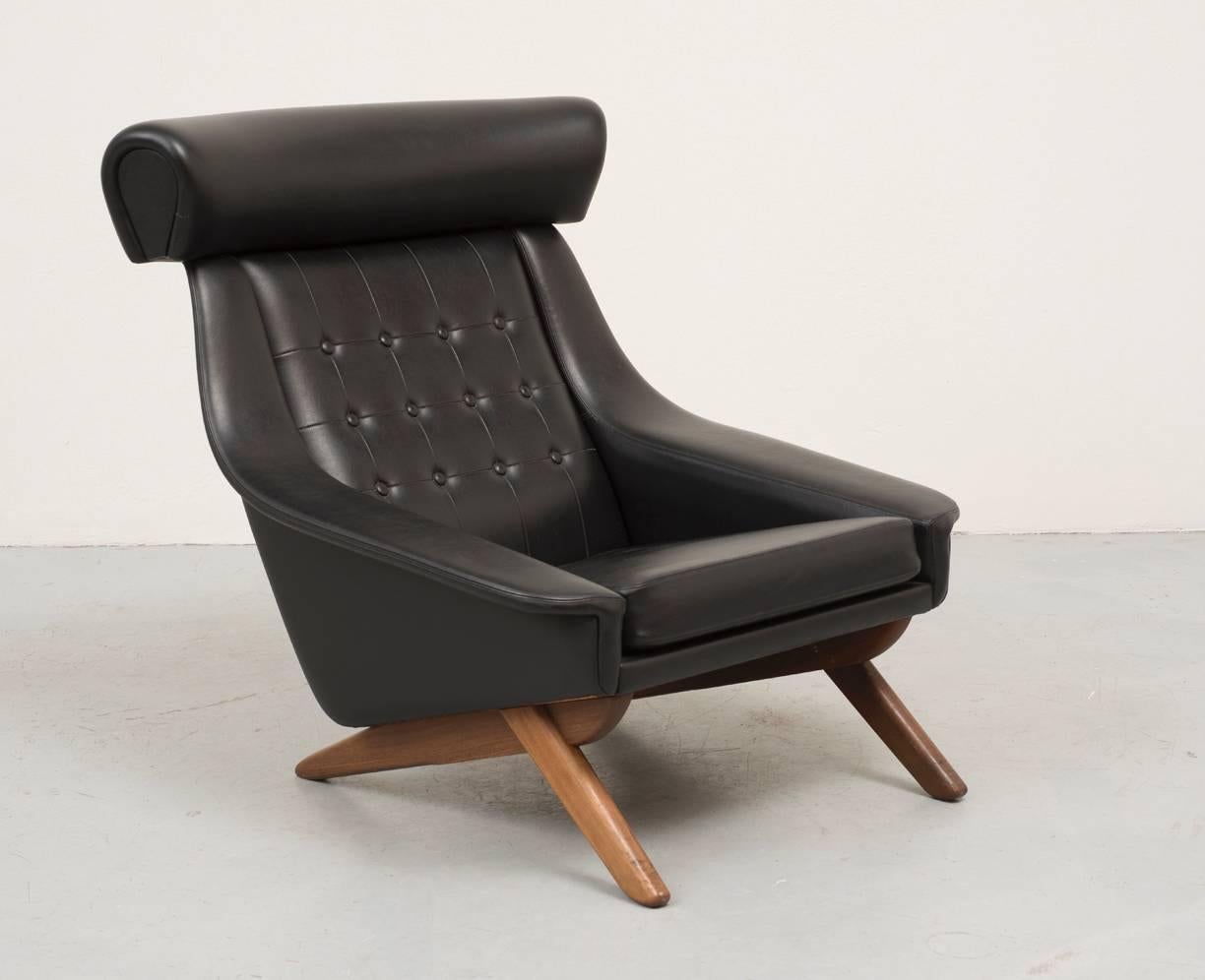 A handsome lounge chair designed by Illum Wikkelsø in original vinyl upholstery with teak frame. Iconic design with scissor legs and button-tufted back. This chair is as comfortable as it is beautiful, circa early 1960s.