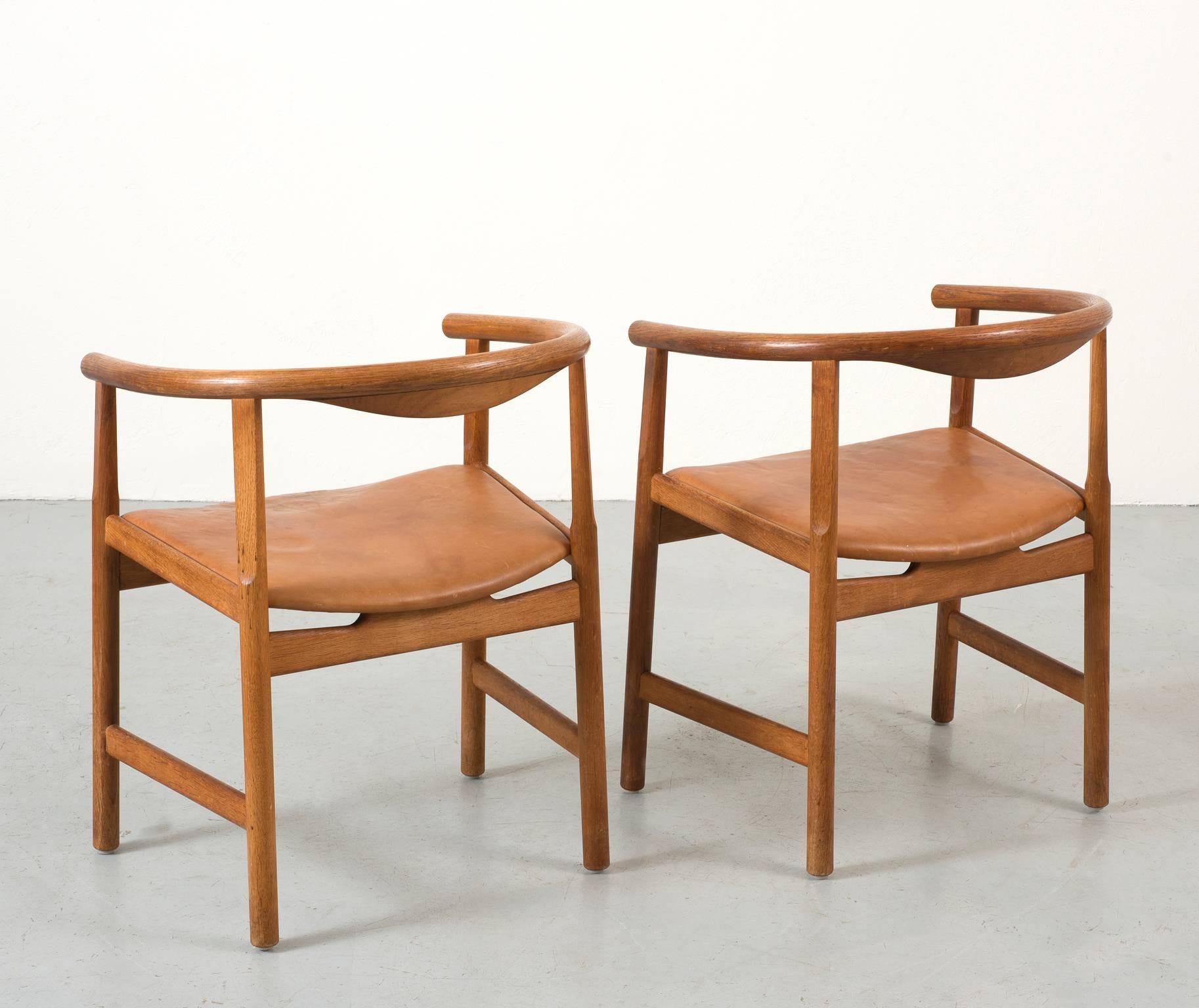 A pair of Hans Wegner armchairs in oak with wenge inlay. Seats in original leather with lovely patina. Produced for PP Mobler, Model PP 201, 1969.