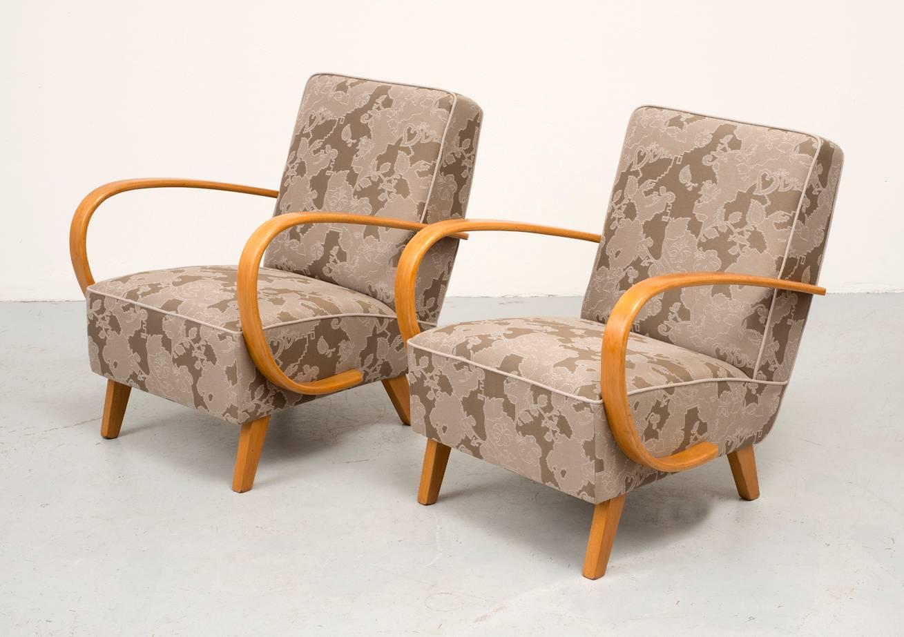 A pair of Art Deco lounge chairs designed by Jindrich Halabala in 1930. Graceful curved beech arms restored with French polish technique. Reupholstered in Maharam Garden fabric. Manufactured by UP Zavody.