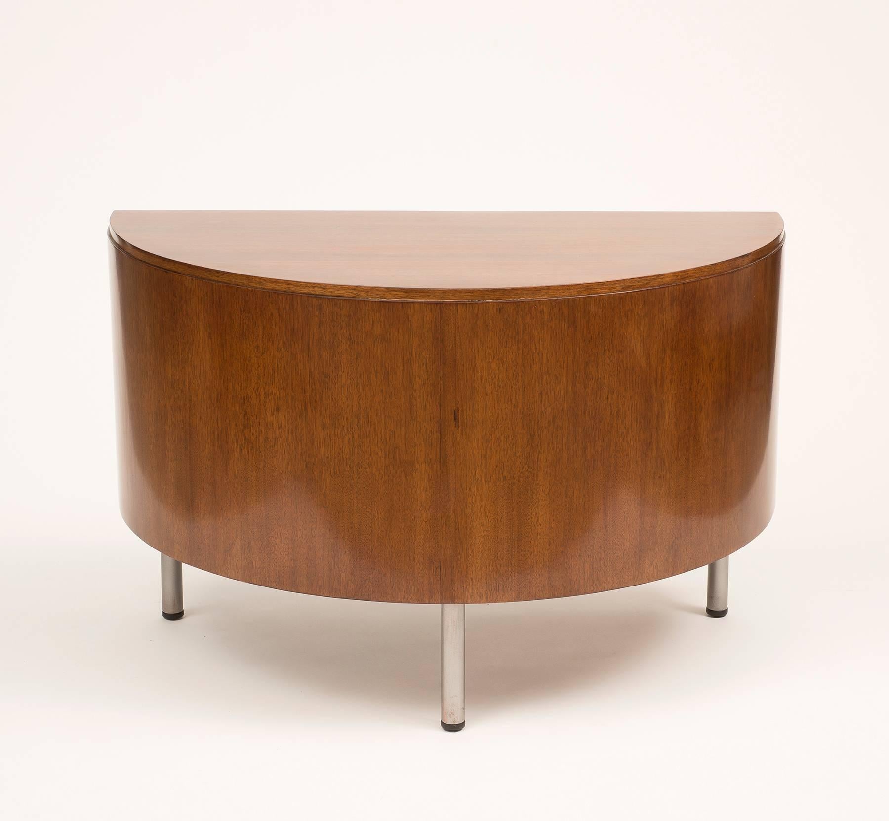 An elegant demilune writing desk in walnut by Gilbert Rohde with chrome legs. Designed in 1942 for Herman Miller.