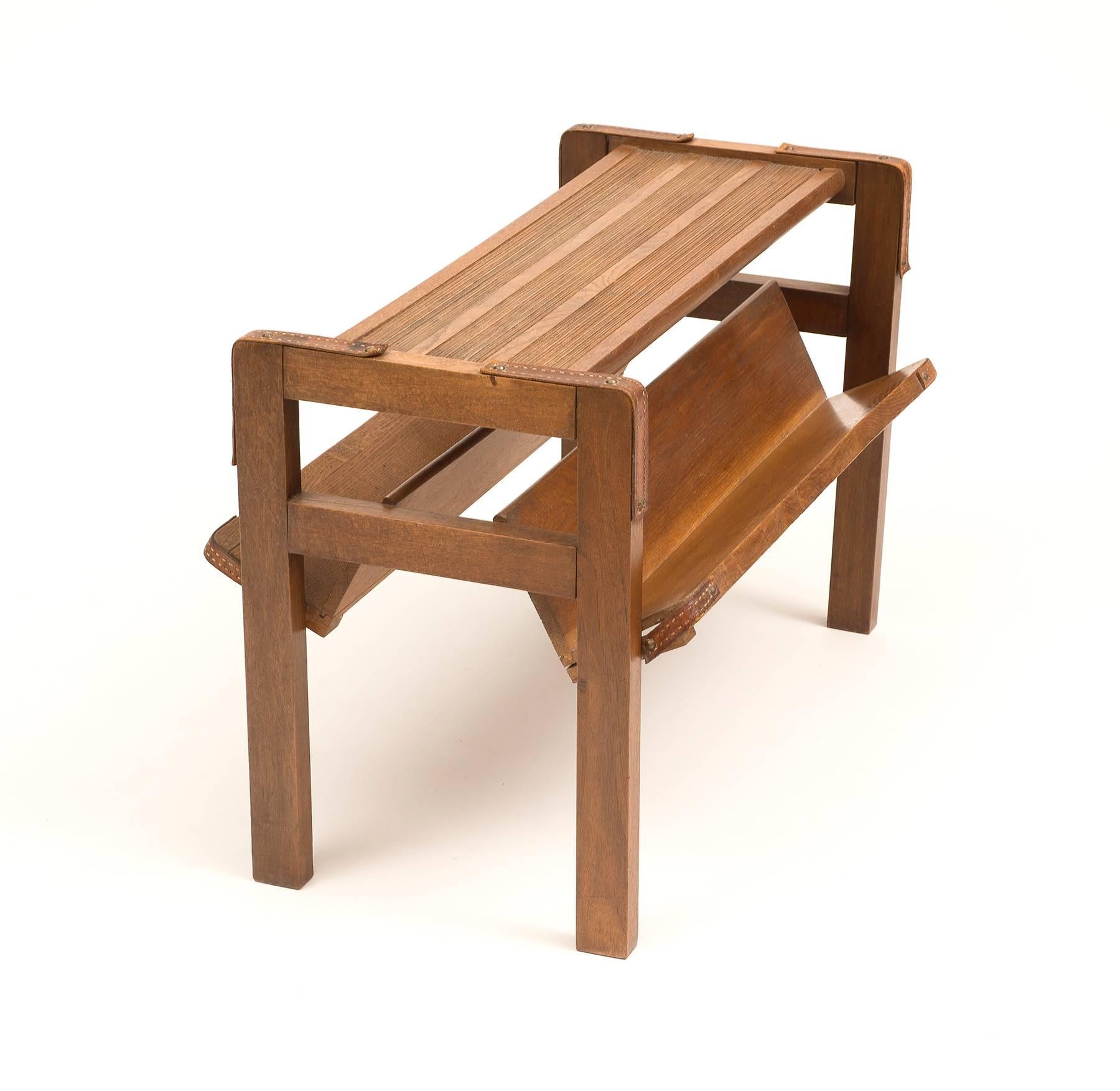 A handsome side table by Jacques Adnet in oak and leather. Lovely patina to both the oak and leather, circa 1950s.