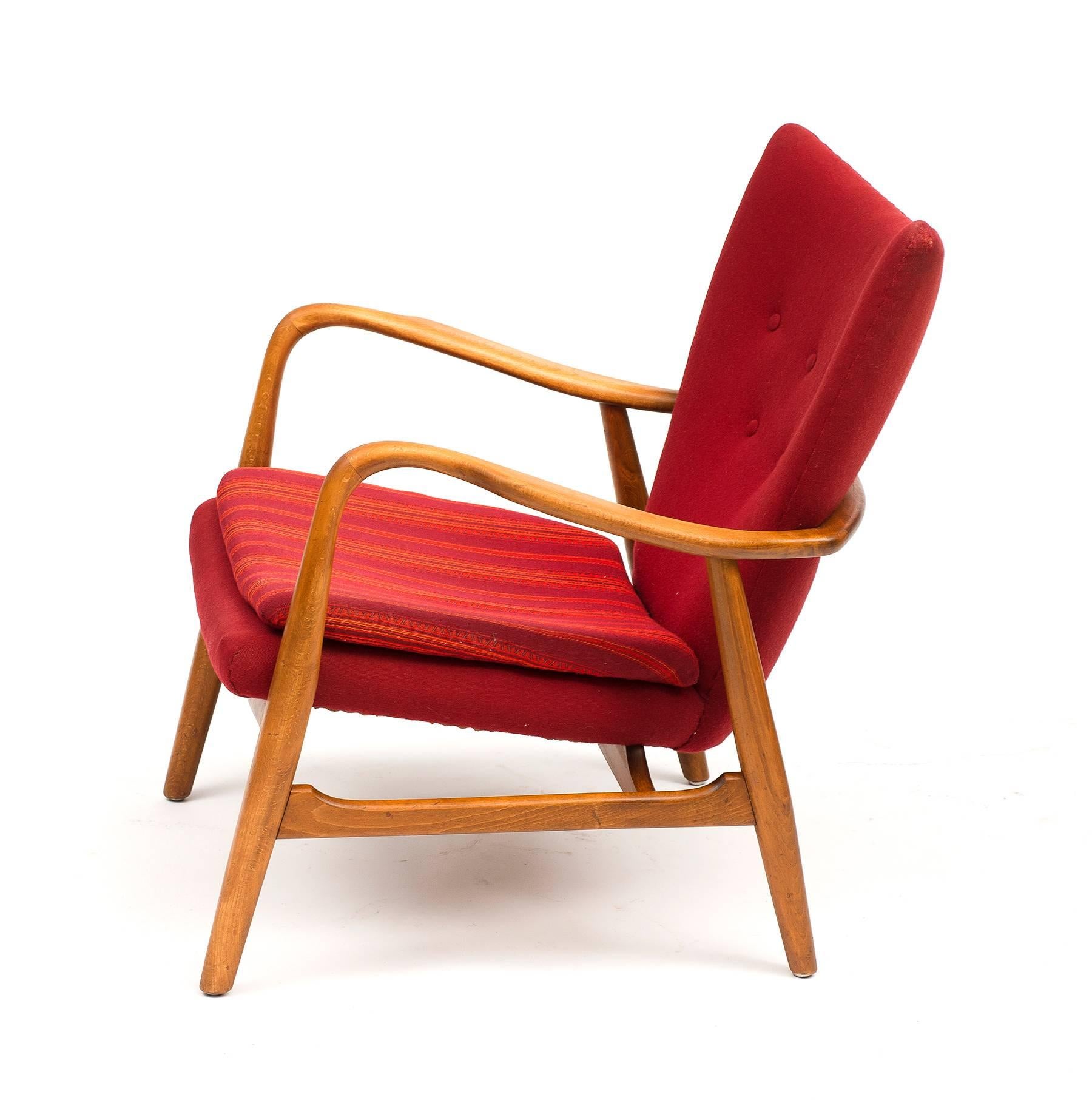 A lounge chair by Acton Schubell and Ib Madsen with frame in beech, upholstered with red wool and striped red seat cushion. Manufactured by Madsen and Schubell, Denmark, 1950s.