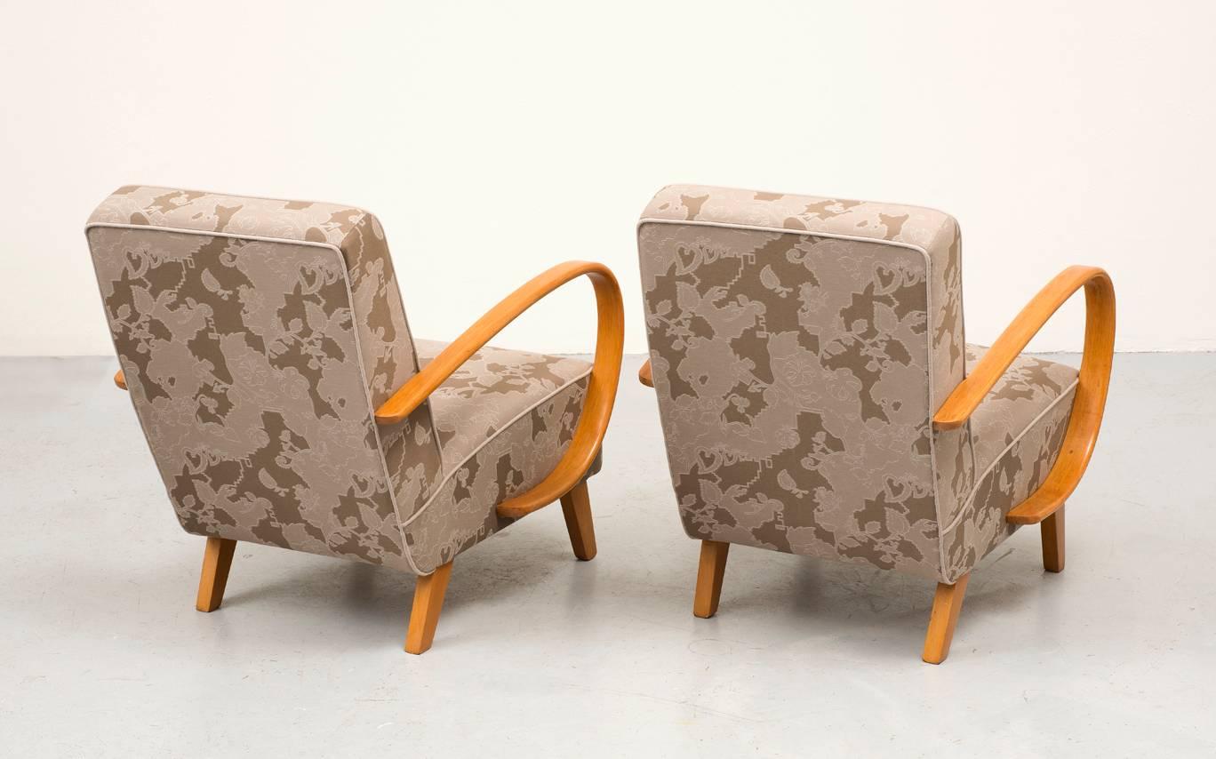 A pair of Art Deco lounge chairs designed by Jindrich Halabala in 1930. Graceful curved beech arms restored with French polish technique. Reupholstered in Maharam Garden fabric. Manufactured by UP Zavody.