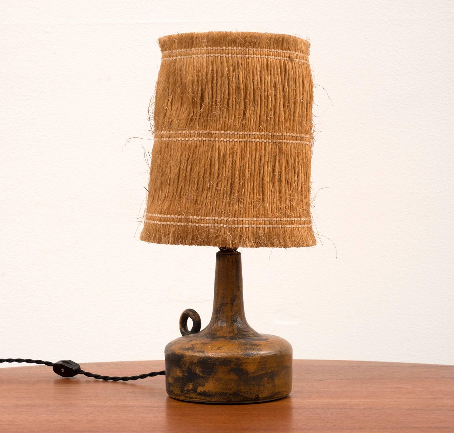 Stunning little lamp in ceramic with rust and black sgraffito glaze by Jacques Blin. With original raffia shade, signed 