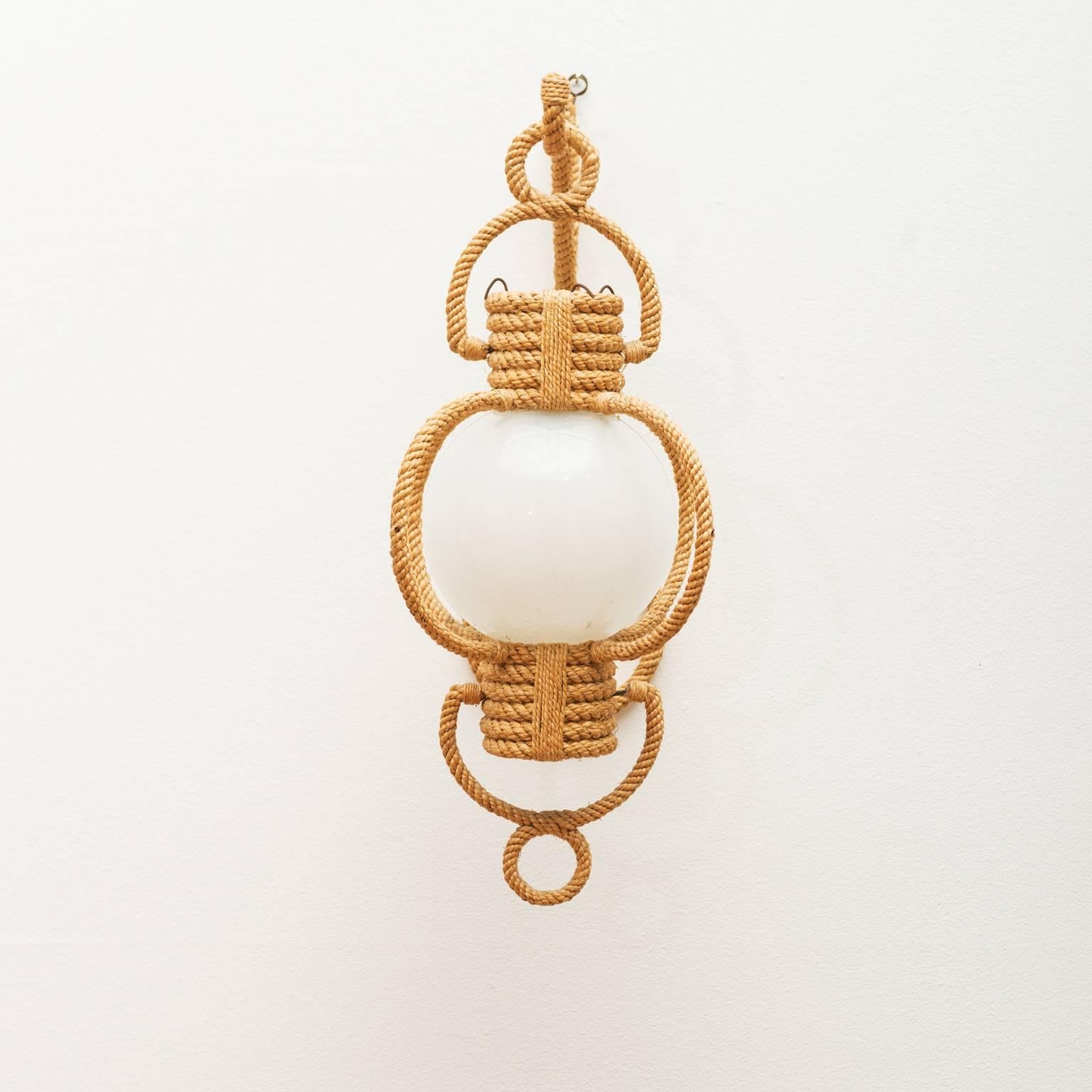 A lovely rope sconce designed and executed by French Riviera designers Adrien Audoux and Frida Minet. With original glass globe, France, 1960s.

European socket and wiring.