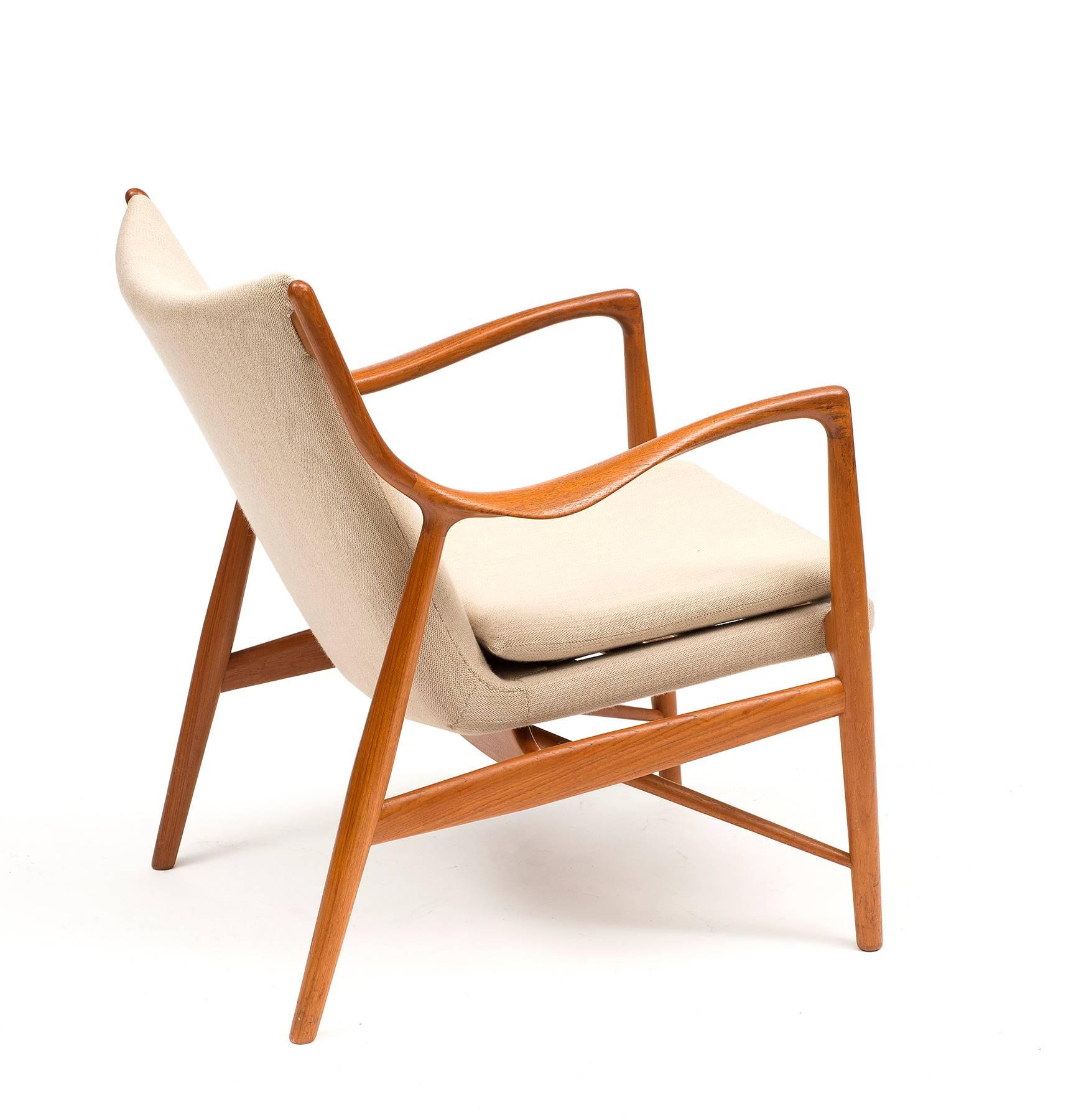 A teak easy chair by Finn Juhl model NV45 in cream wool. Manufactured by Niels Vodder, Denmark, 1950s.