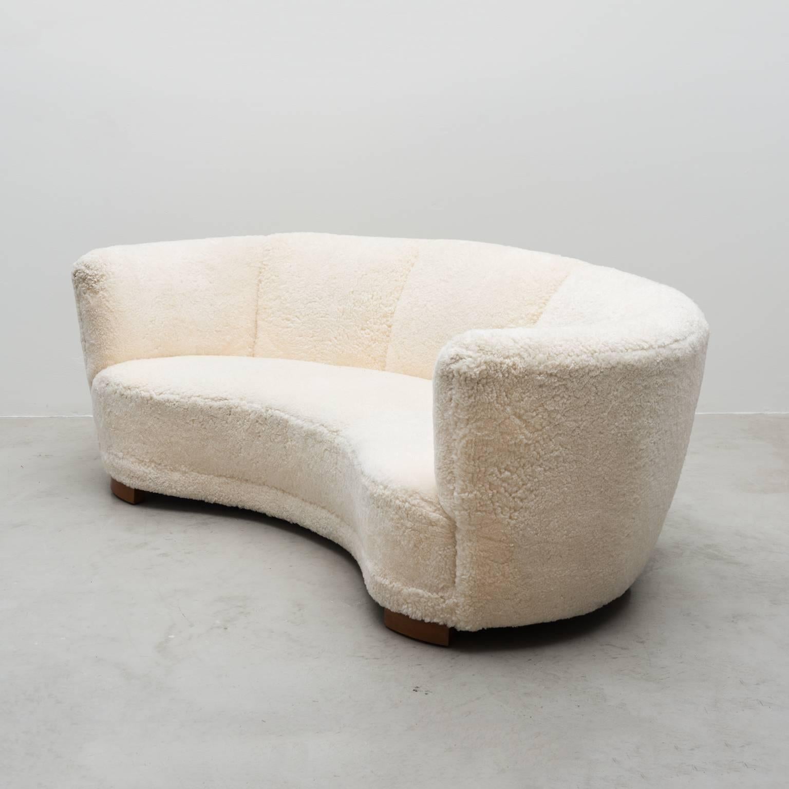 A Danish cabinetmaker's graceful curved three-seat sofa with beech legs, reupholstered in short white sheepskin, 1930s.