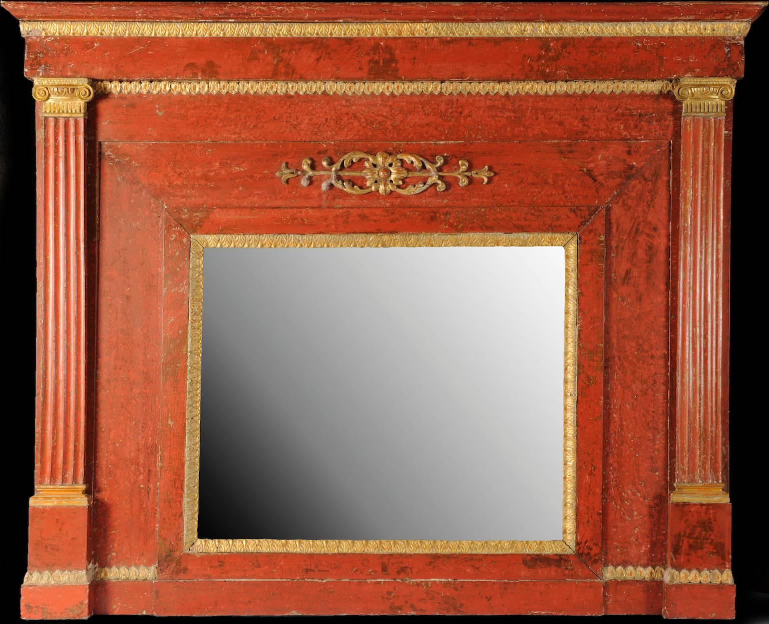 Early 19th century red Armenian bole painted and partially giltwood mantel mirror of Lombard origin. A neoclassical rectangular frame with an antique mercury mirror within giltwood acanthus leaves applied profile, two side carved fluted carved