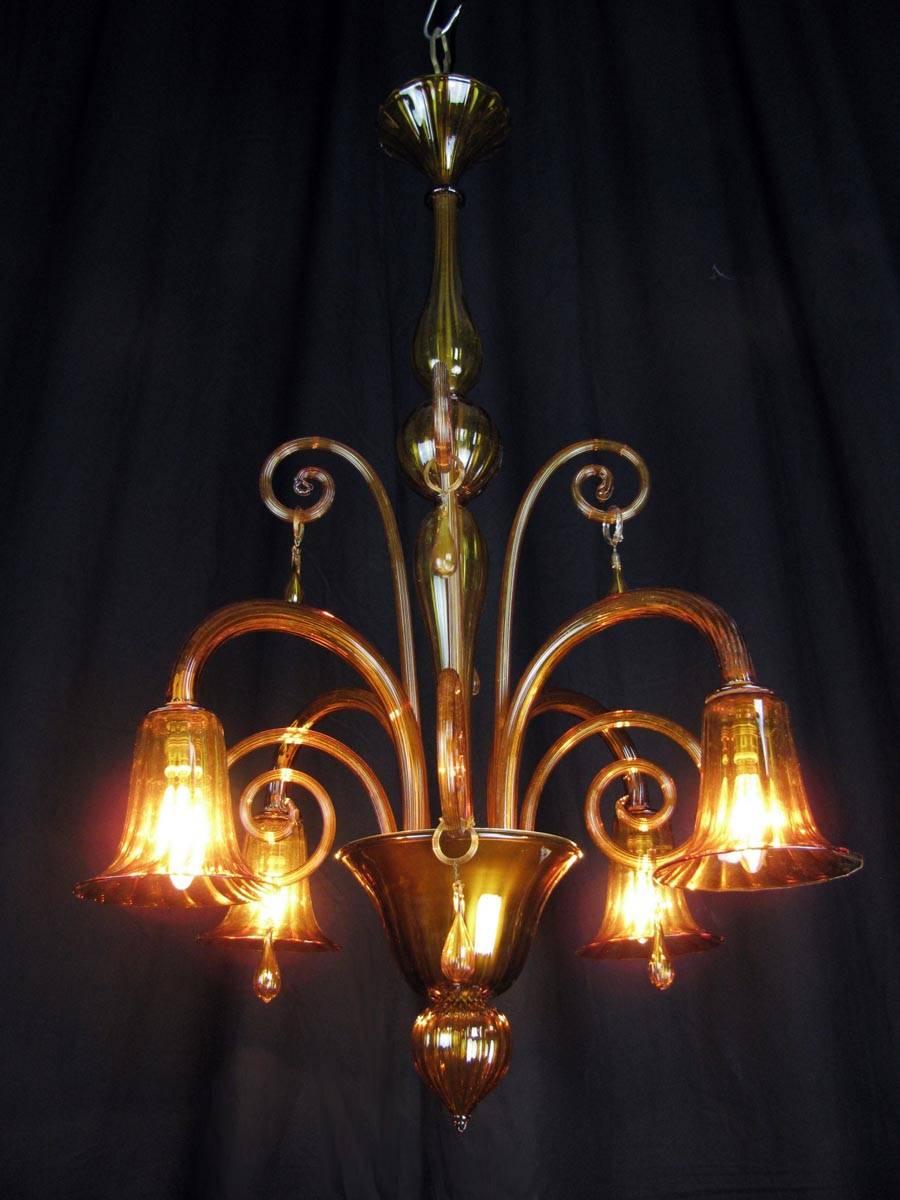 1930s Venetian Murano glass chandelier. A charming Italian Murano antique chandelier in amber color blown glass, coming from a private residence in Milan and dating back to 1930s. The tall structure with a central steam made of two bottle shaped