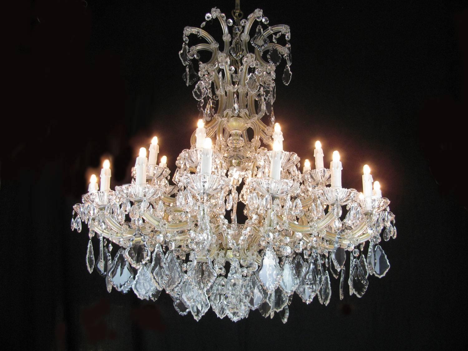 A large Italian Maria Theresa style cut-glass twenty four-light chandelier dating back to 1950s. This lovely extra-large chandelier (or hanging fixture) of crystal, glass and gilt metal featuring 16 serpentine arms, the arms alternating between one