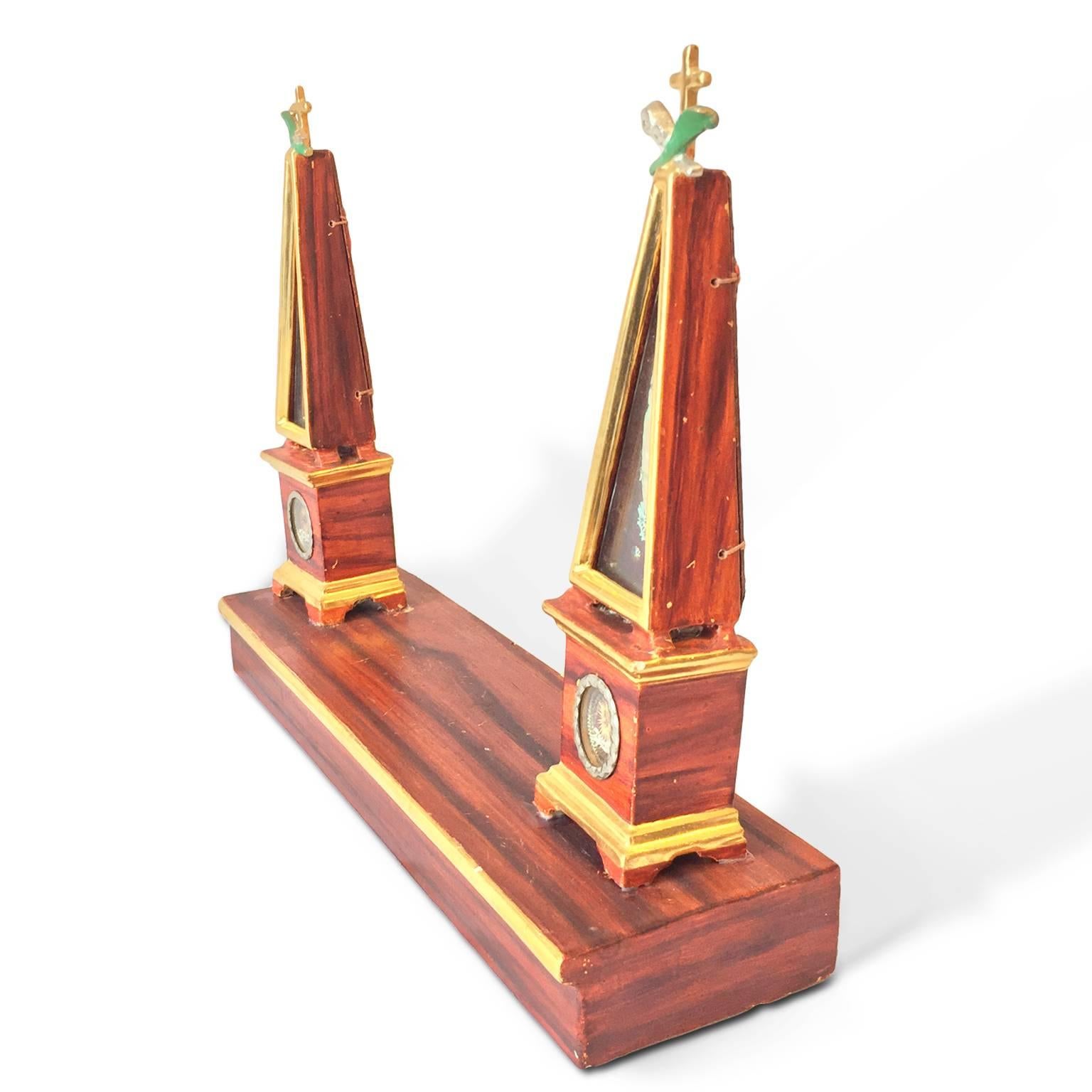 A very rare Italian obelisk-shaped showcase reliquary realized in carved poplar, partially gilded and red painted, resting on a rectangular base; the back side is not decorated and shows wax seals. This unique artwork of Tuscan origin dates back to