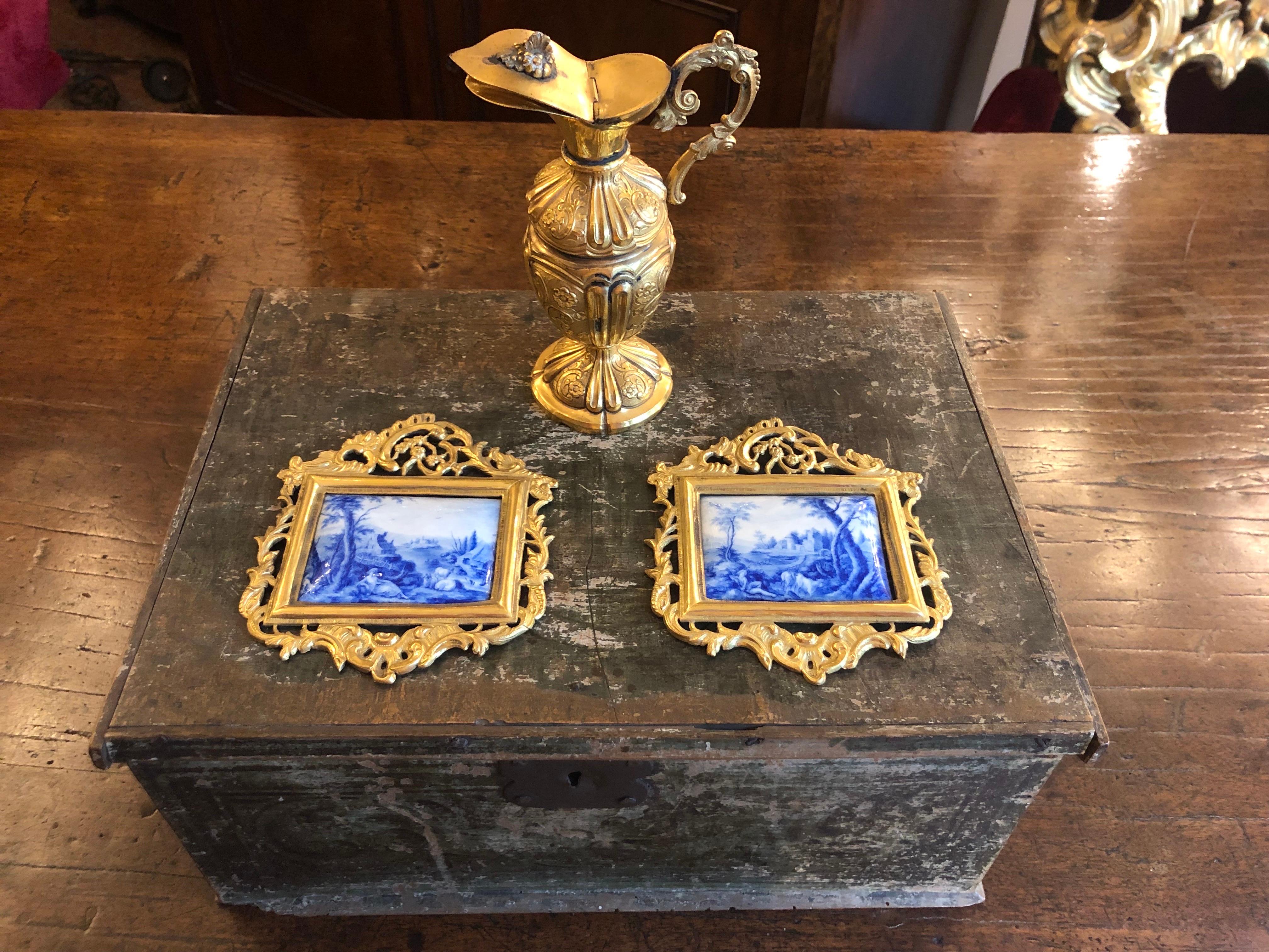 Coppia di dipinti in miniatura con paesaggi bucolici e figure nei toni del blu, due placche In smalto dipinte con paesaggi con figure entro cornici dorate, di provenienza europea e probabilmente francese eseguite su di una placca di metallo