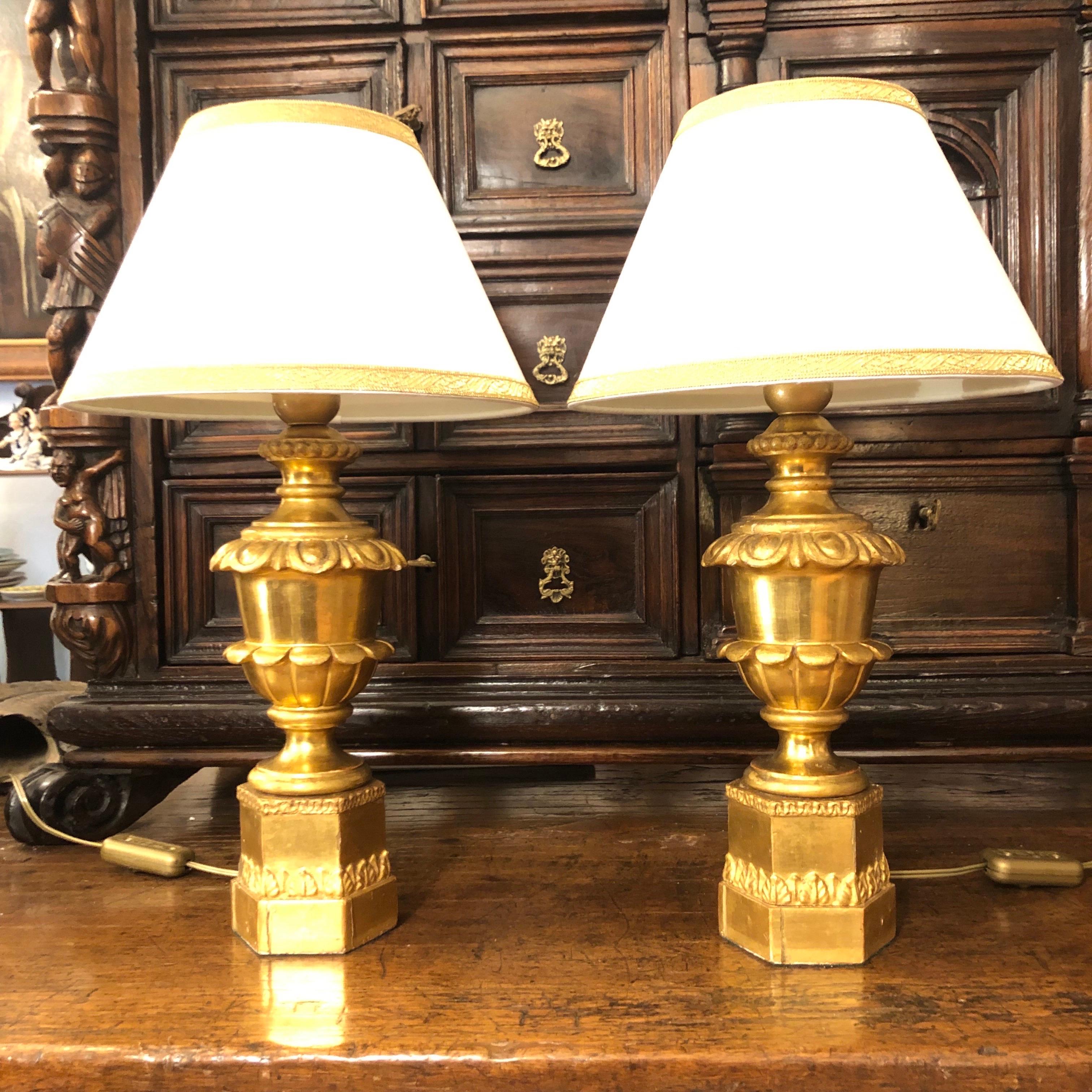 Pareja de antiguas lámparas imperio italianas doradas del siglo XIX en madera tallada, pieza central, realizada con remates de principios del siglo XIX, jarrones sobre zócalo hexagonal con marcos de talla vegetal en pastille, montadas a modo de