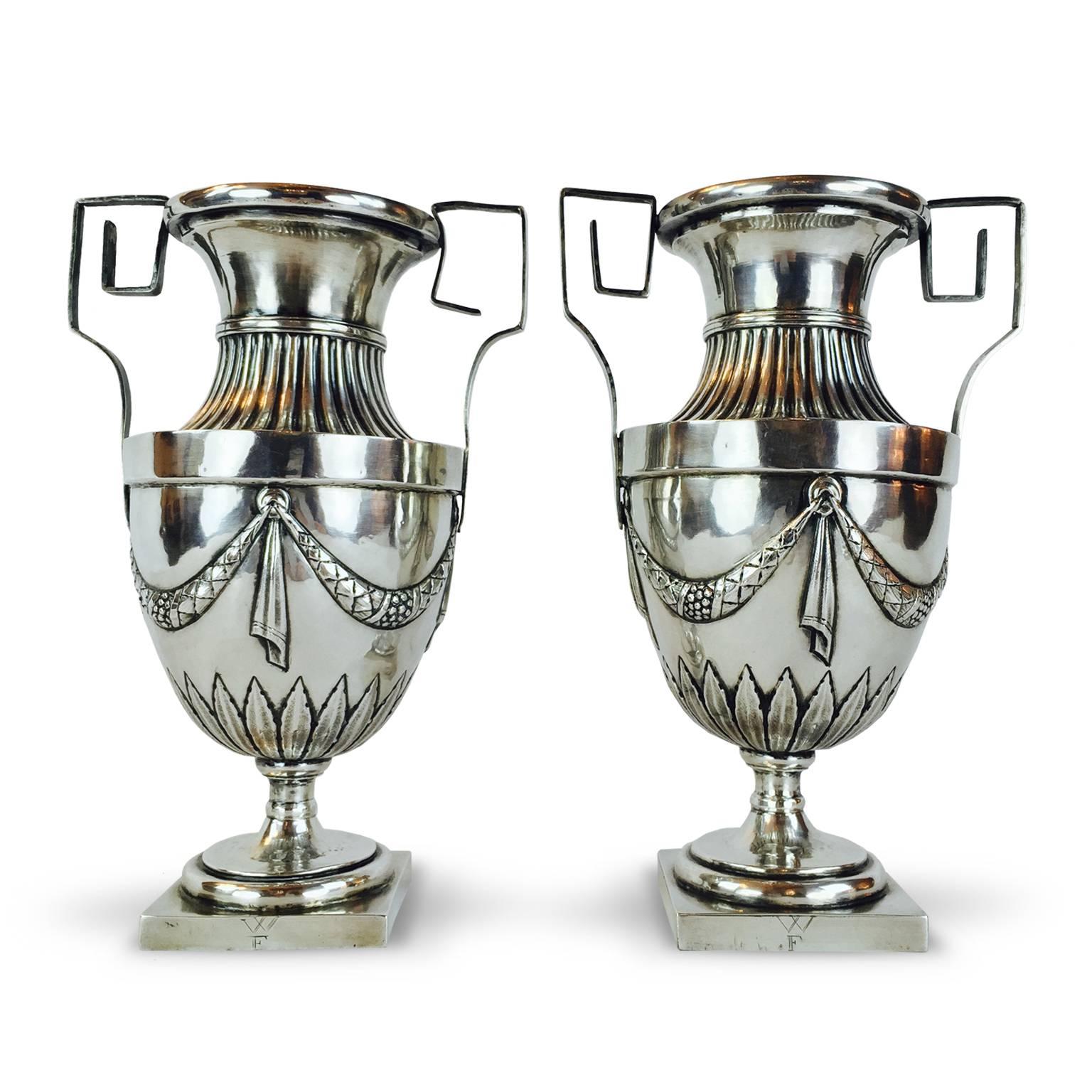A rare pair of antique Louis XVI embossed silver vases with geometric handles made by Italian silvermaker Paolo Ruzzoli, as Grand Tour souvenir, memento for the Elite travellers.
The square base is engraved with W F initials, may be related to the