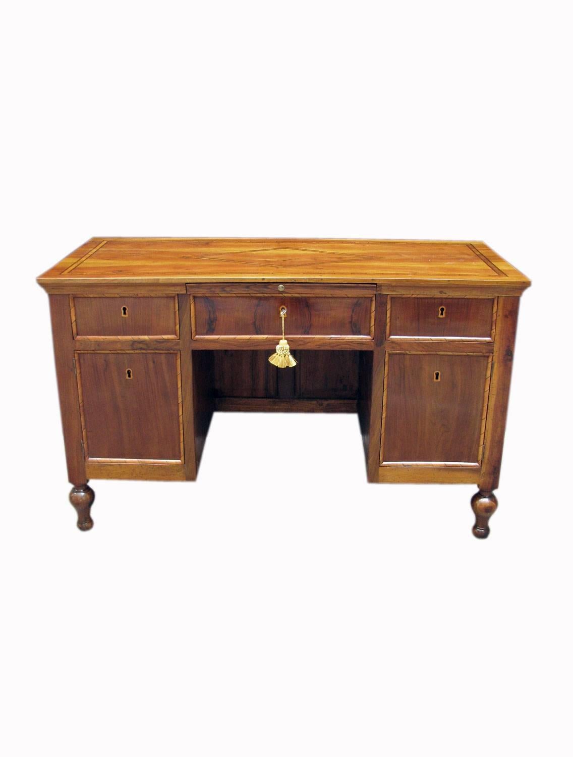 Mid-19th century Italian walnut writing table, knee hole desk with three drawers, and two doors. Solid walnut top, centered by elegant geometric inlay marquetry; front, sides and back are walnut veneered, decorated with spectacular molding frames,