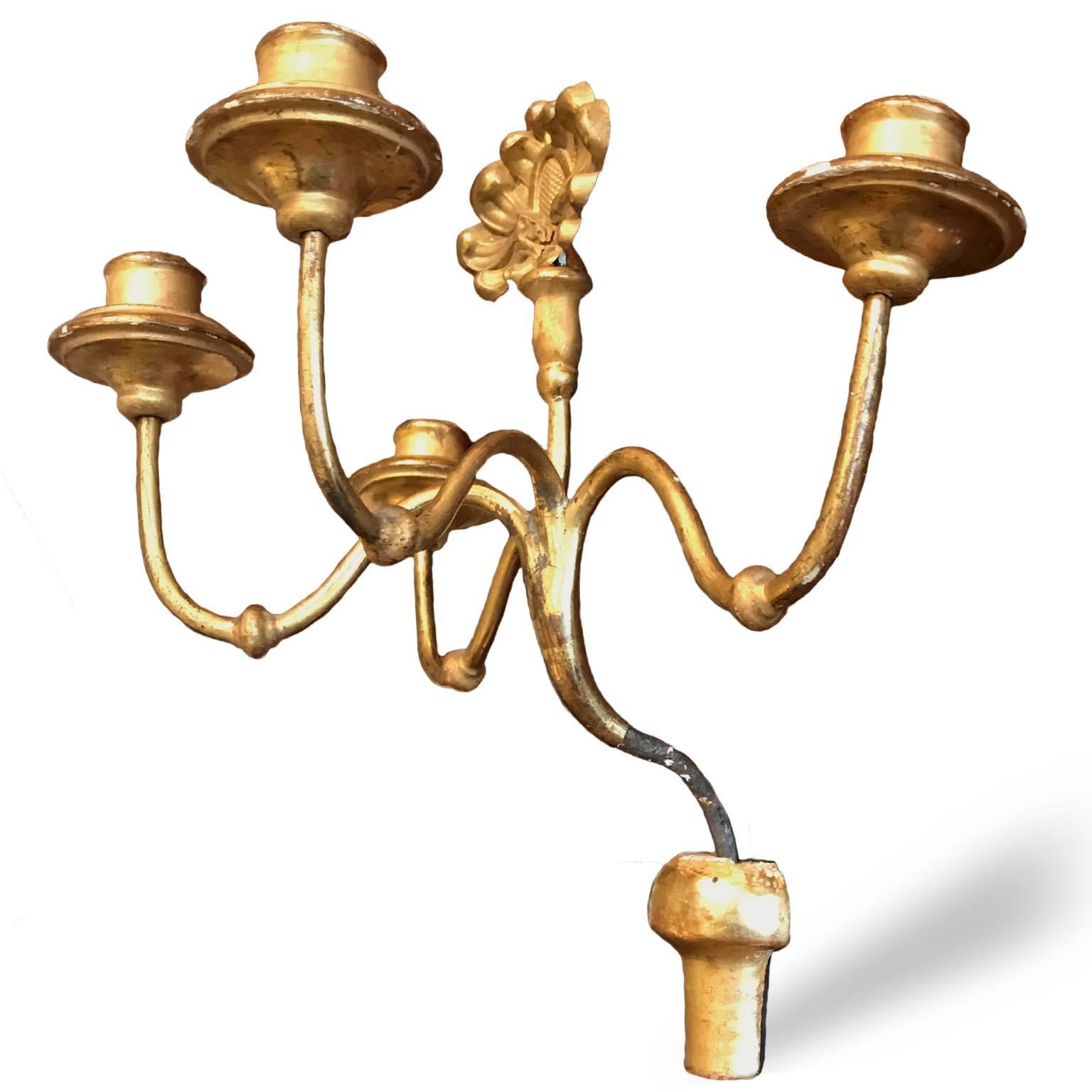 Pair of early 19th century Piedmontese gilded iron wall candleholders, antique wall appliques candelabra from Italy, realized with an iron structure, four curved iron arms ending with removable giltwood bogeiges. 
The central part of each gilded