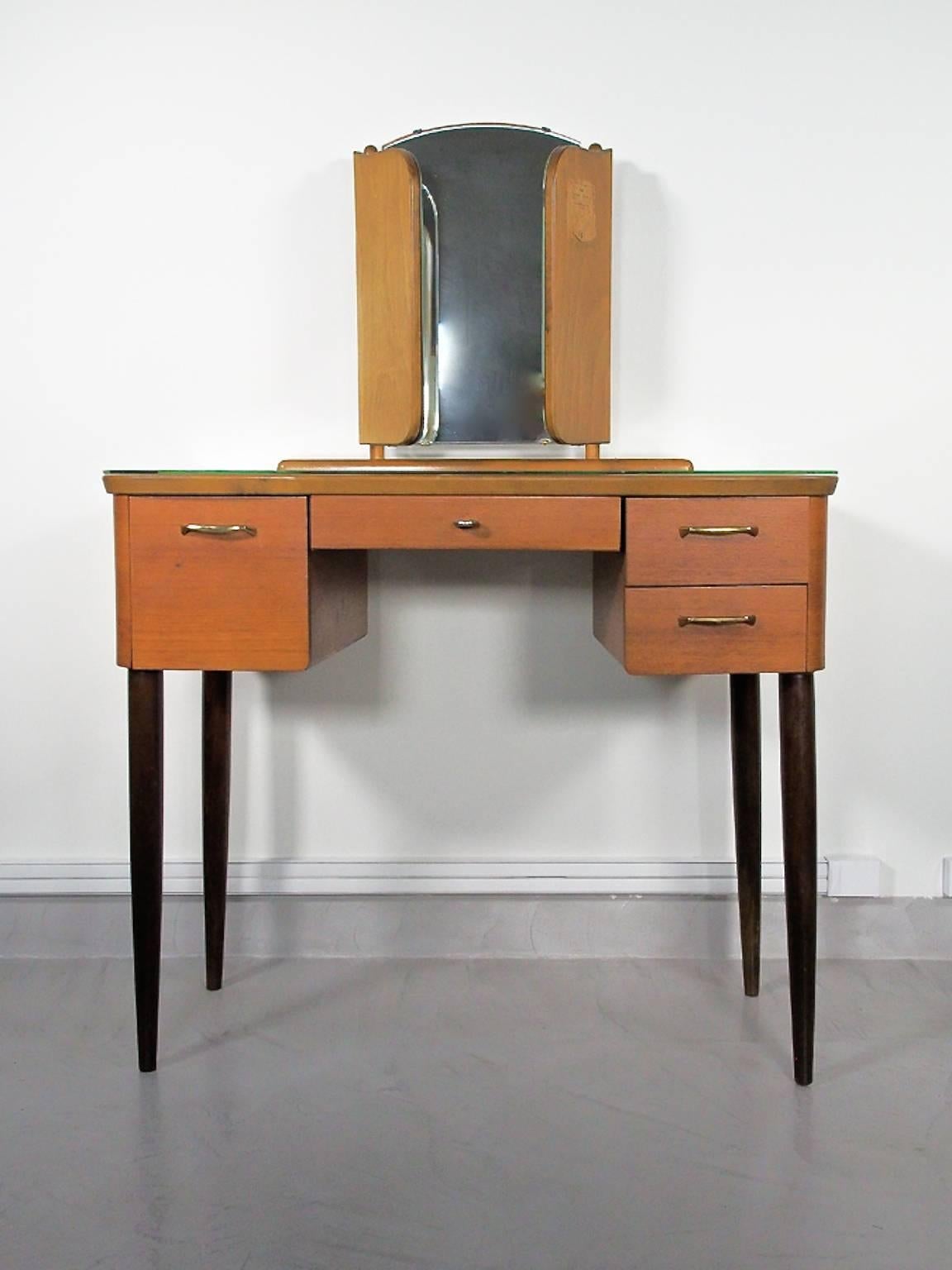 Beautiful Mid-Century Modern teak dressing table with angled mirror and glass top. Drawers in the front. Round stained wood legs. Manufactured in Sweden by Fröseke AB.