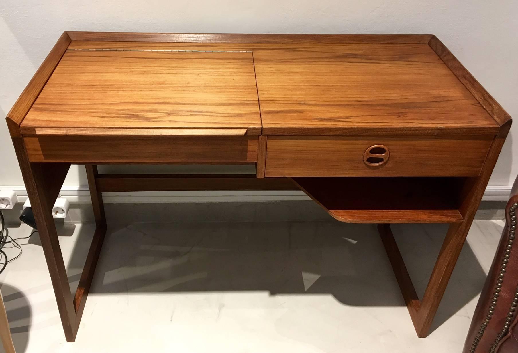 Mid-Century teak desk/dressing table. One side of the tabletop reveals a mirror and small compartments when lifted up. Other side with a drawer.