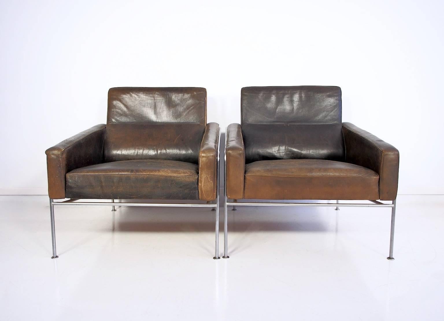 Pair of lounge Airport chairs, with chromed metal frame, upholstered in black leather. Produced by Fritz Hansen, model 3300. 

Designed by Arne Jacobsen (1902-1971). Truly amazing looking in a beautiful vintage condition with an outstanding patina