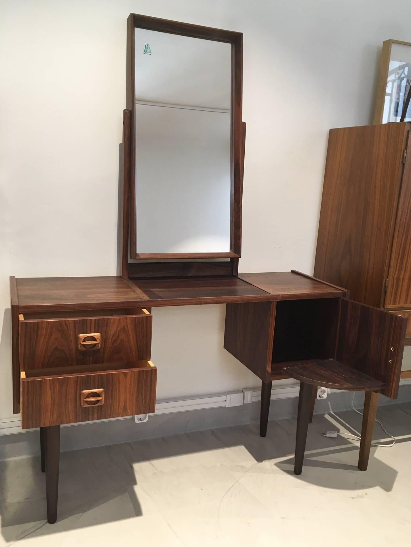 Stunning 1950s Danish dressing table with adjustable tilting mirror, two drawers for toiletries and another storage compartment. Veneered with rosewood. Maker marked as AG Spejl Kobberbeskyttet.