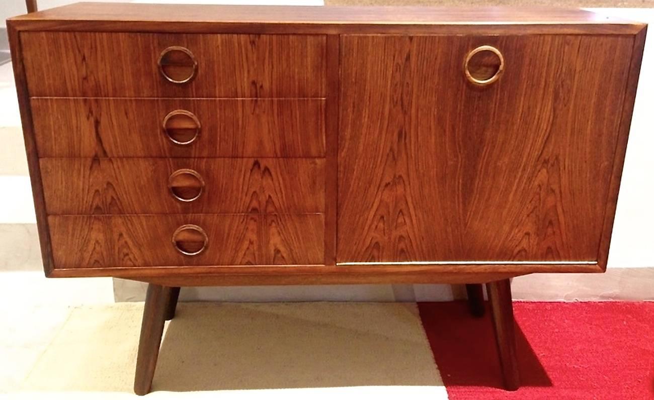Danish TV stand/small credenza made of rosewood with fall-down door, shelving compartment and four drawers on sloping turned legs, circa 1960s.