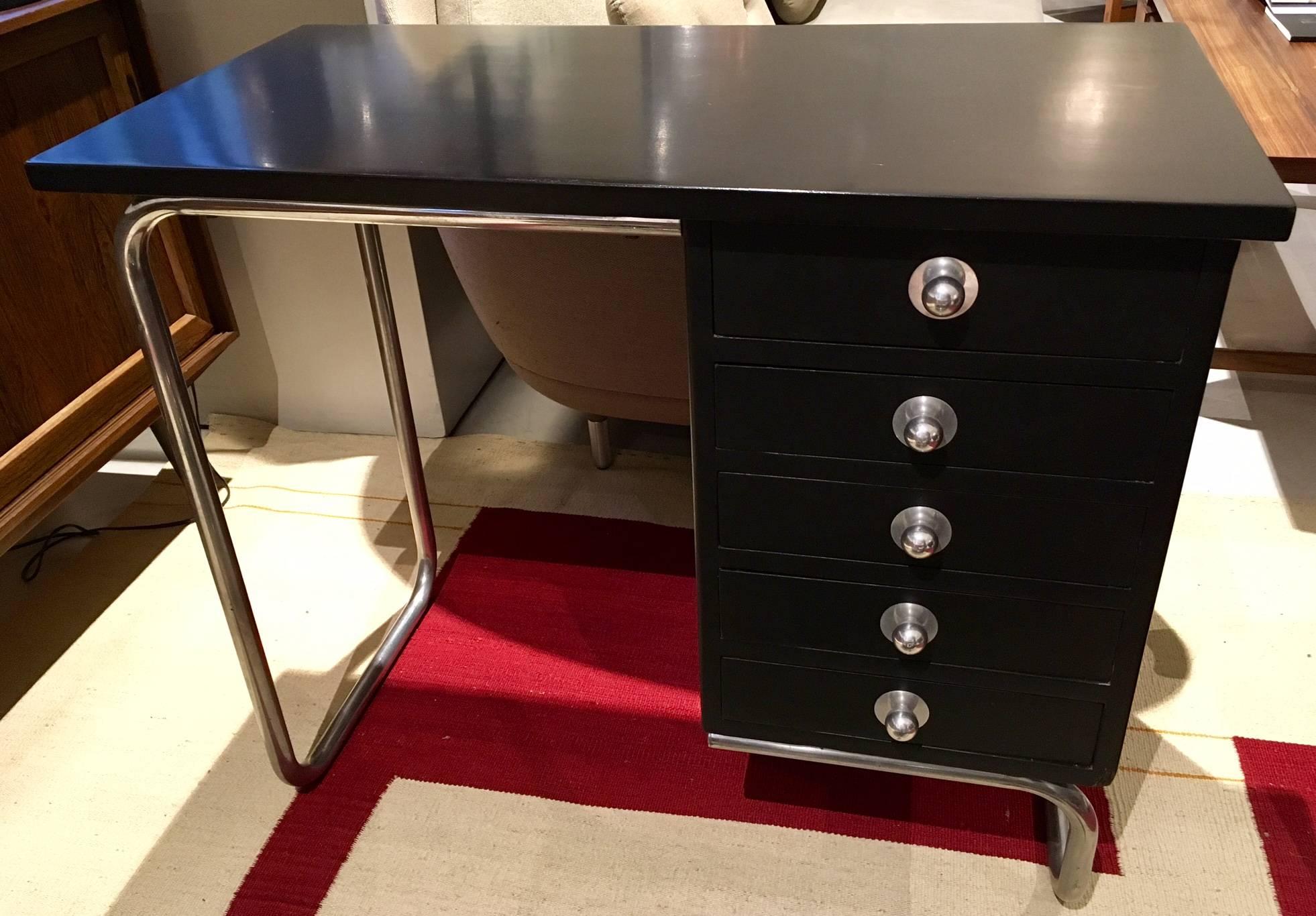 Small writing desk with black lacquered wooden top and drawers, tubular steel frame. Made in Europe, presumably Germany, circa 1935. Some ink stains inside the drawers and a dent on the bottom right corner. See photos.