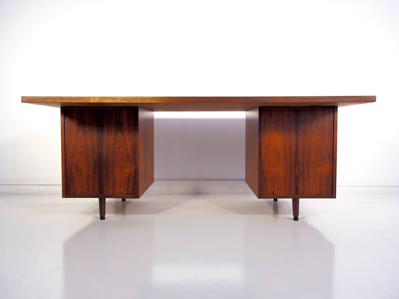 Rosewood writing desk. Front with five drawers, handles made of chromed metal. A few scratches and marks on the top.